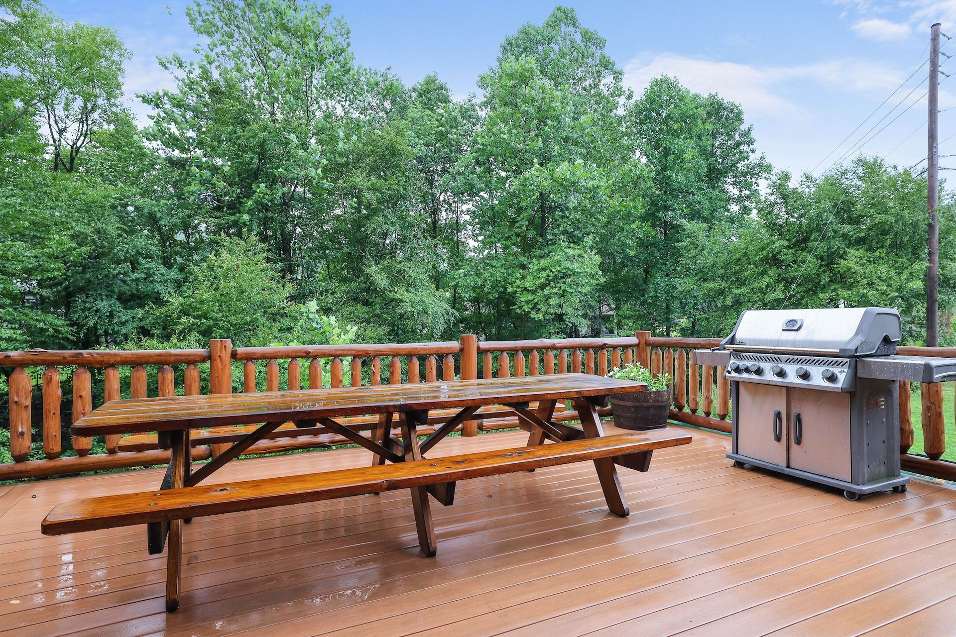 A wooden deck with a picnic table and a grill