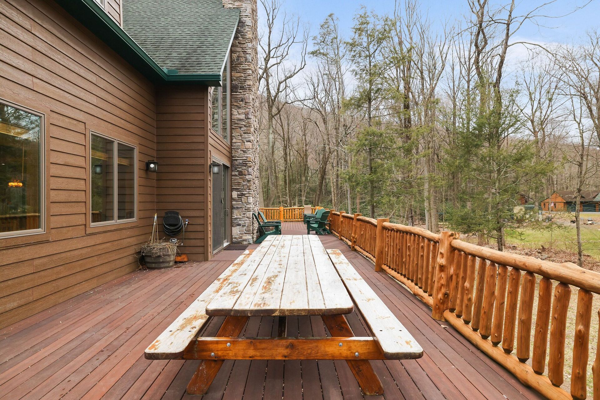 There is a picnic table on the deck of a house.