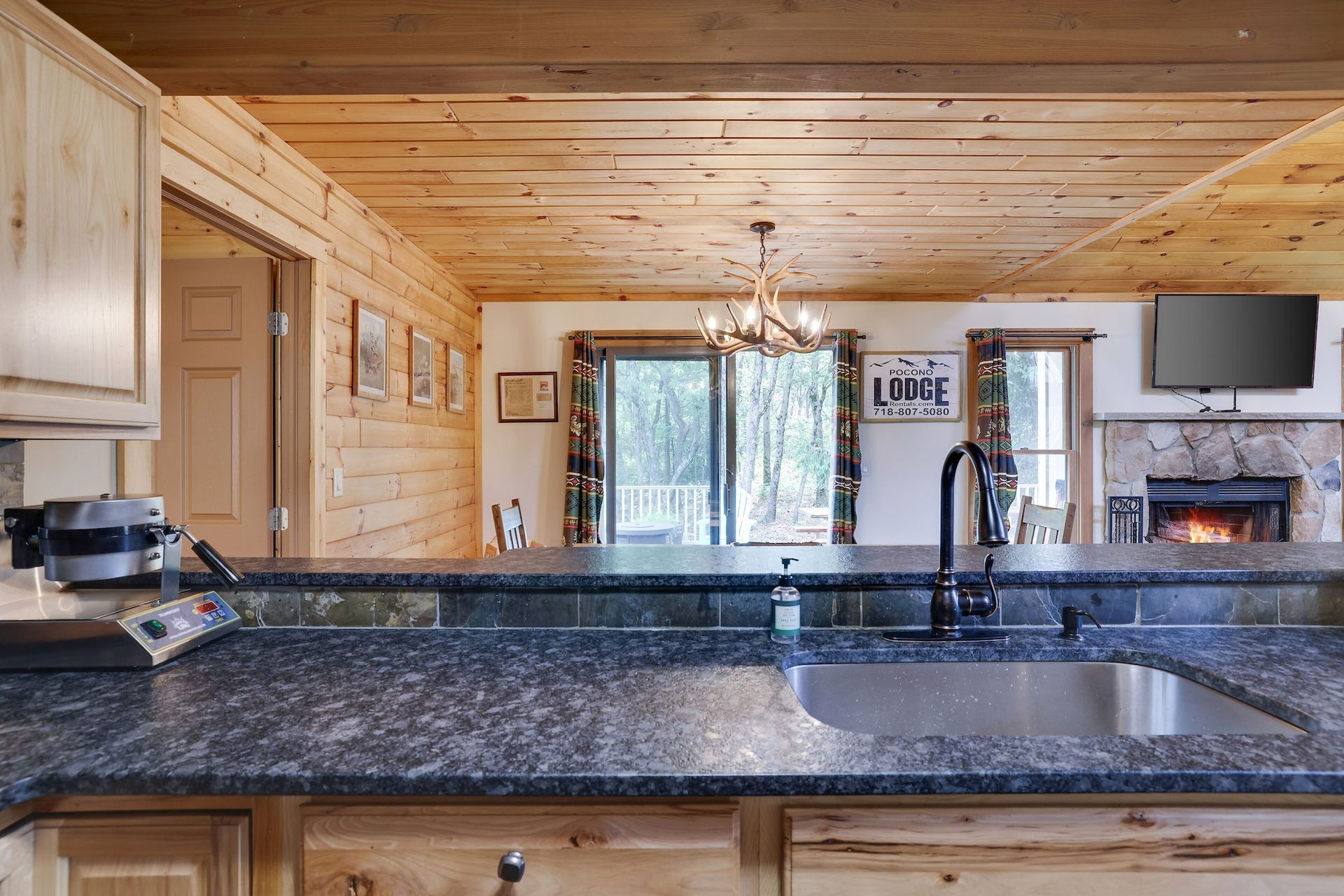 A kitchen with a granite counter top and a stainless steel sink.