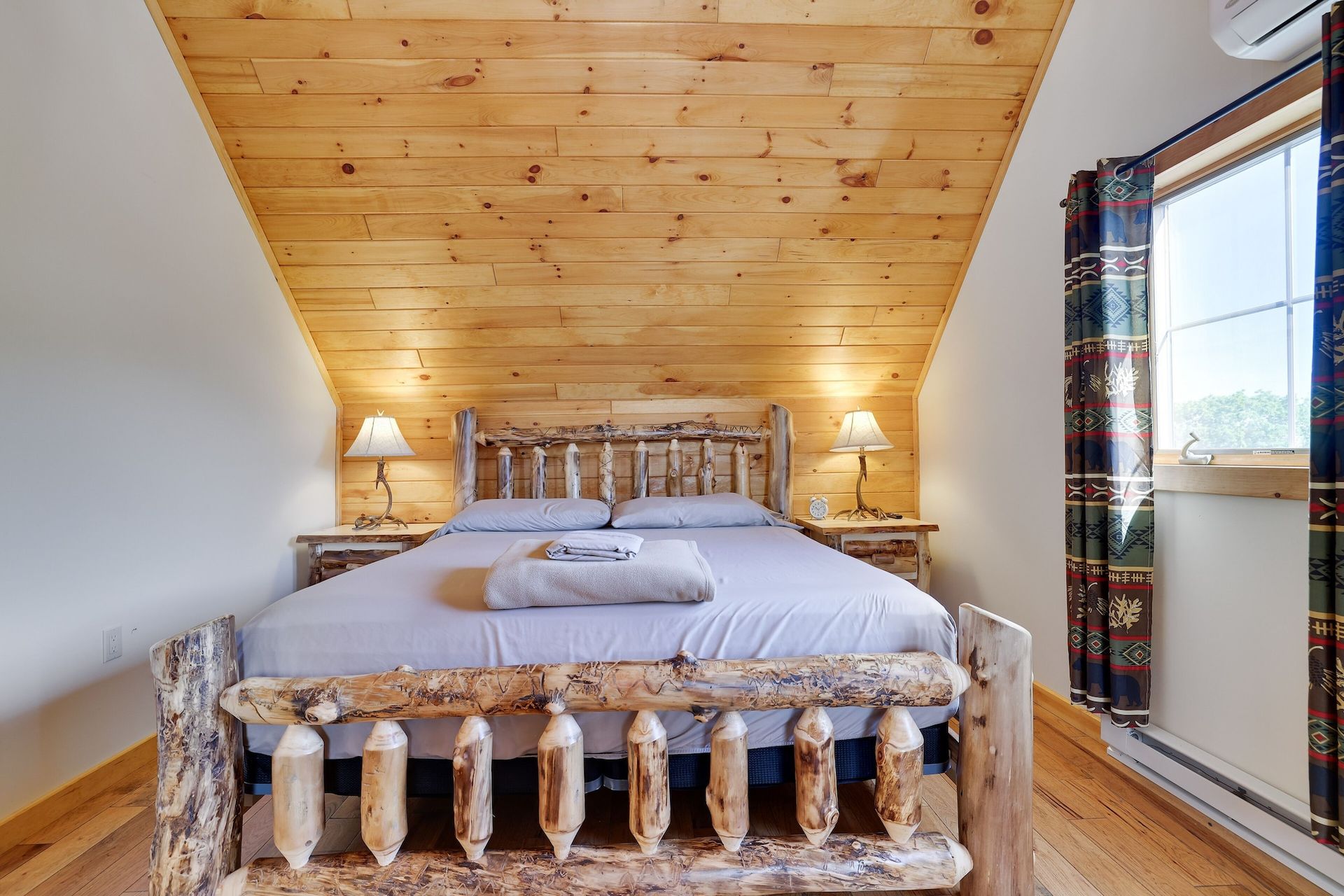 A bedroom with a wooden bed and a wooden ceiling.