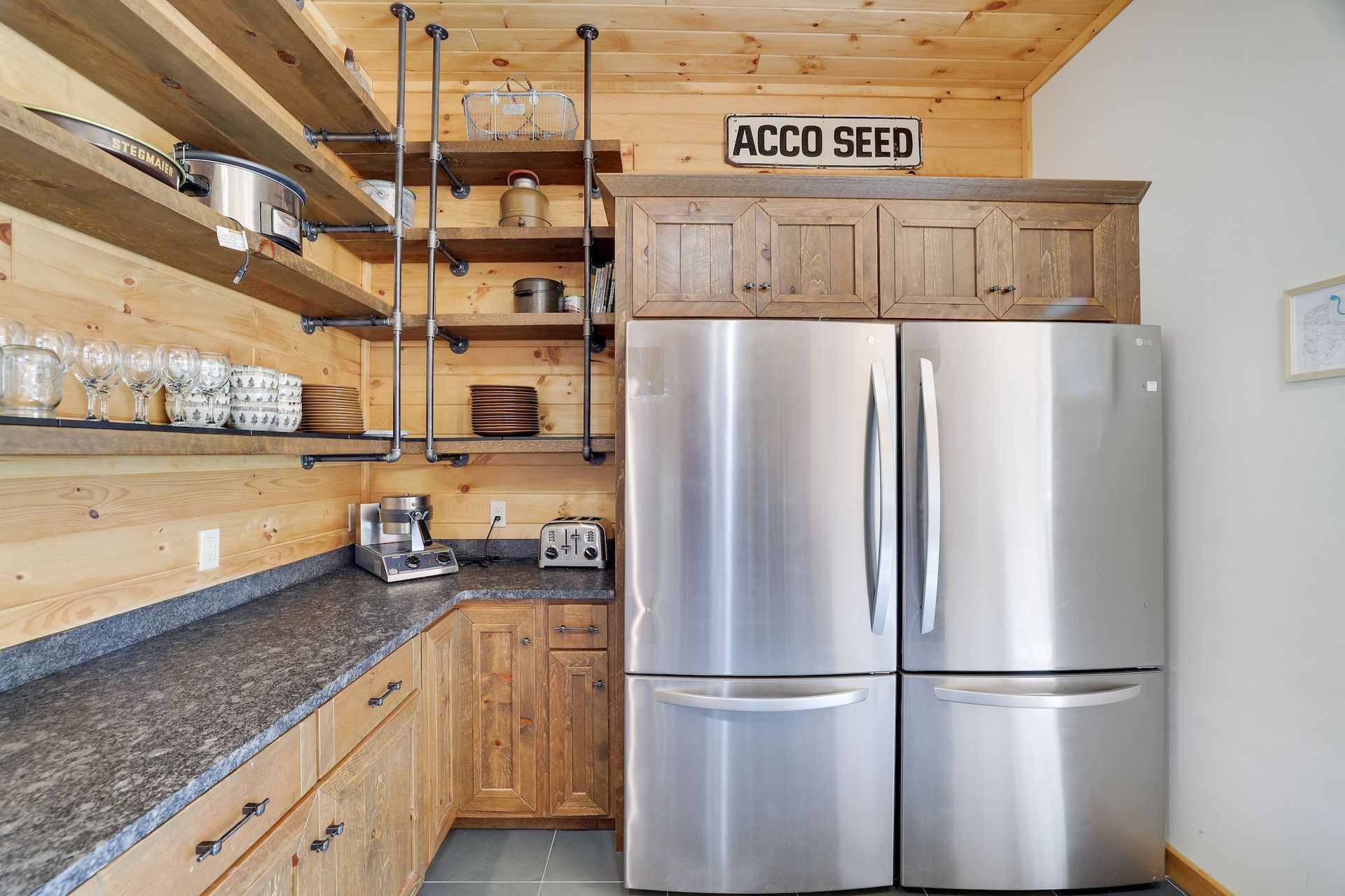 A kitchen with two stainless steel refrigerators and granite counter tops.