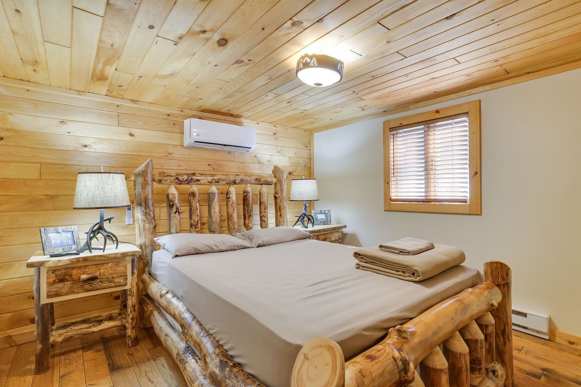 A bedroom in a log cabin with a king size bed and two nightstands.