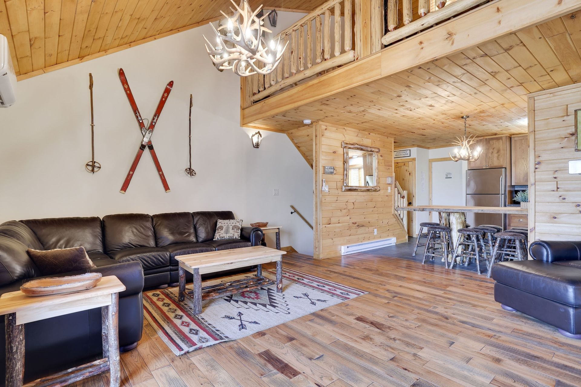 A living room in a log cabin with a fireplace and a flat screen tv.