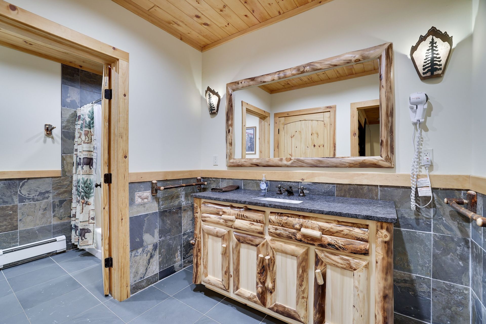 A bathroom with a sink , mirror and wooden cabinets