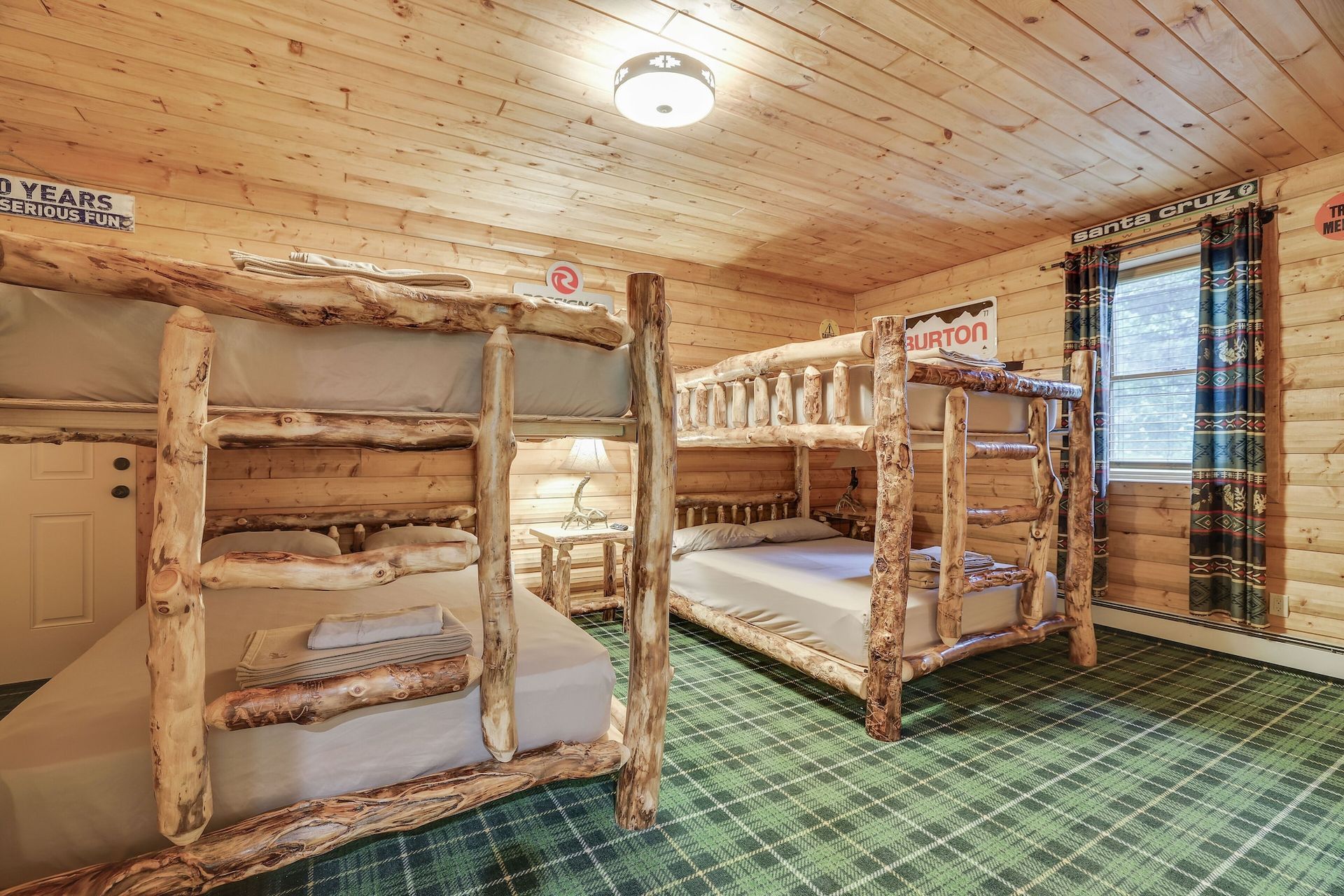 A room with bunk beds made of logs in a log cabin.