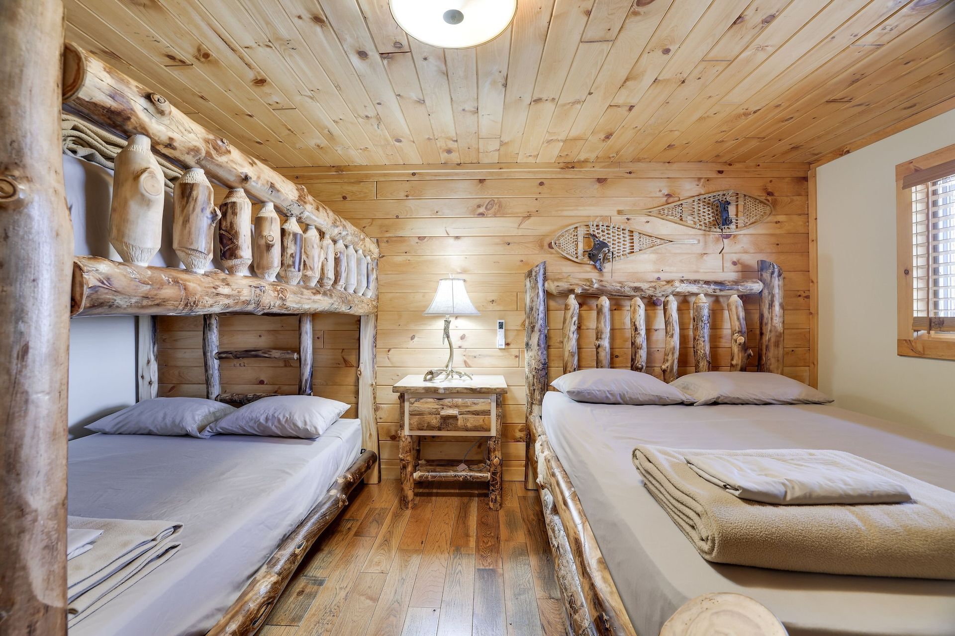 A bedroom in a log cabin with two bunk beds and a large bed.