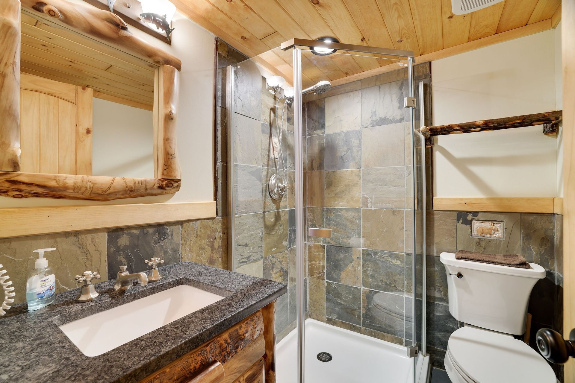 A bathroom with a sink , toilet and shower.