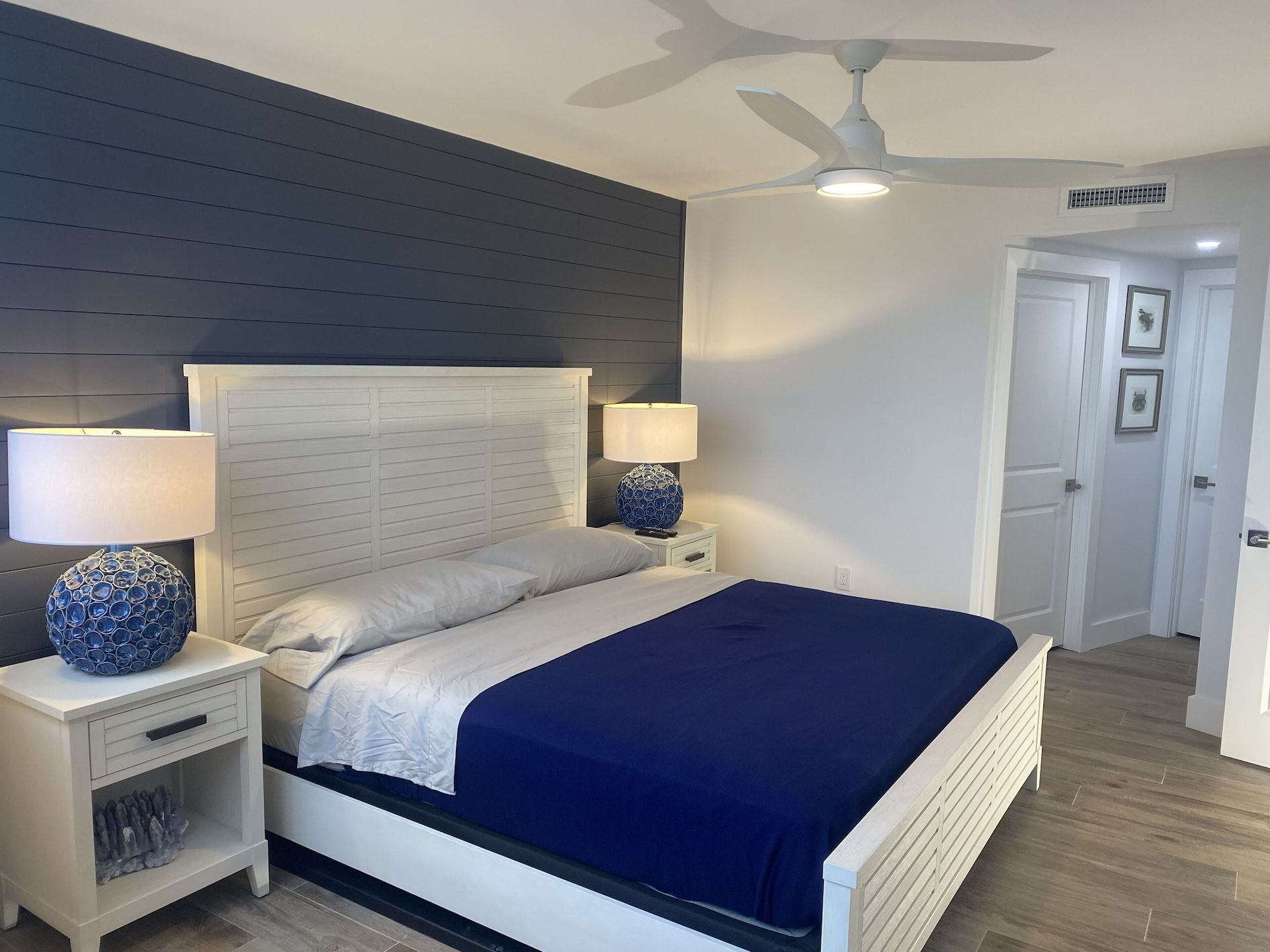A bedroom with a king size bed and a ceiling fan
