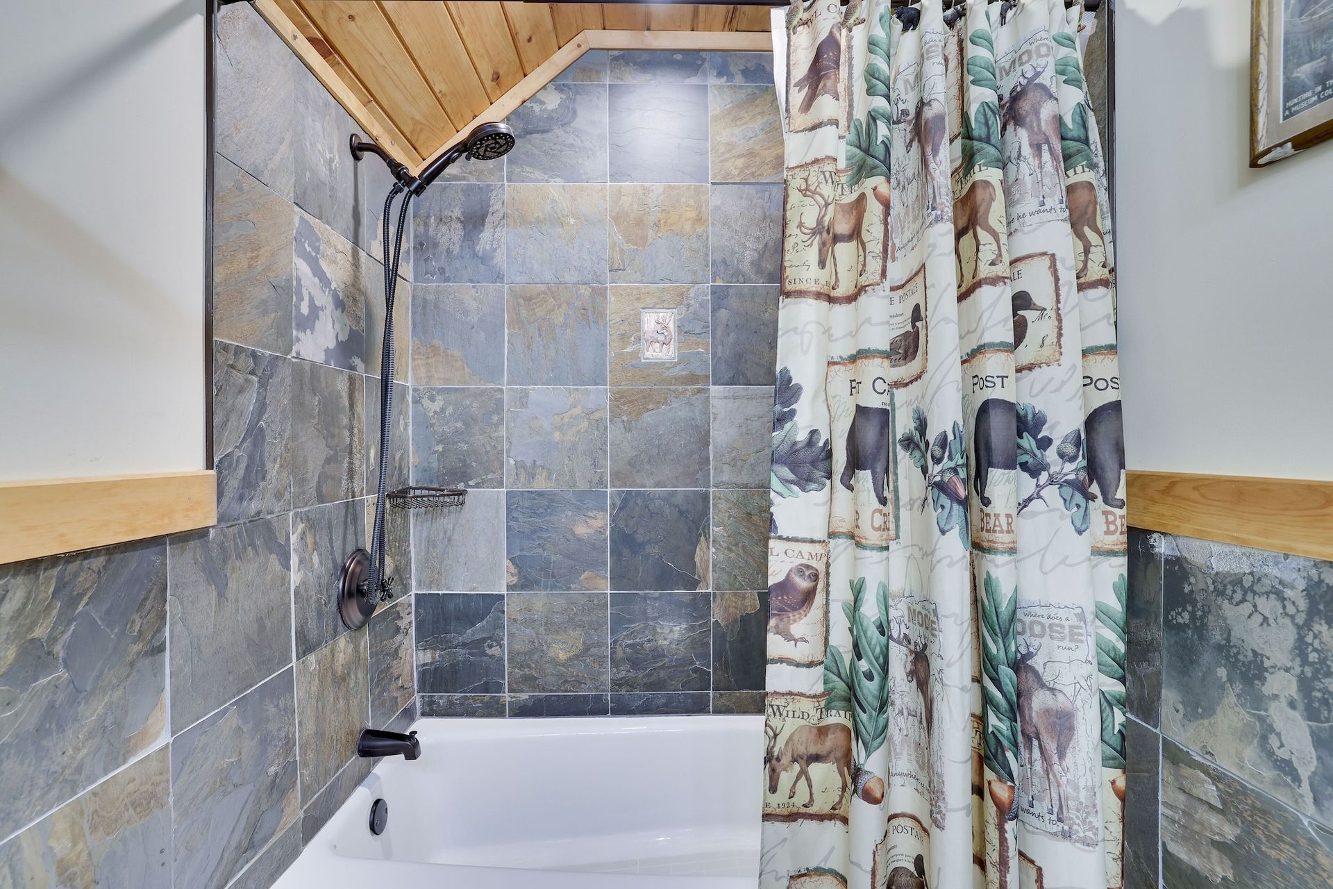 A bathroom with a bathtub , shower , and shower curtain.