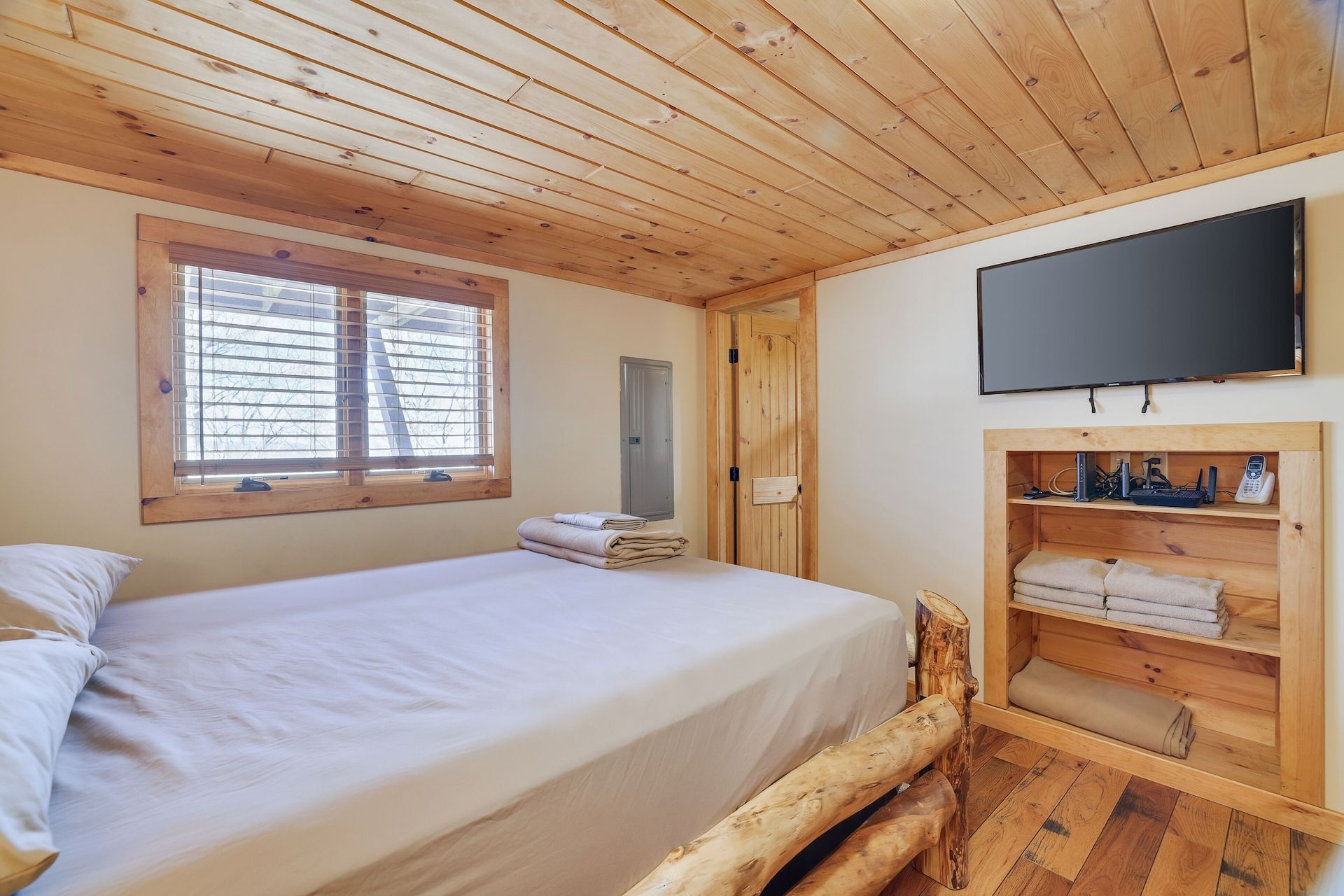 A bedroom with a bed and a flat screen tv.