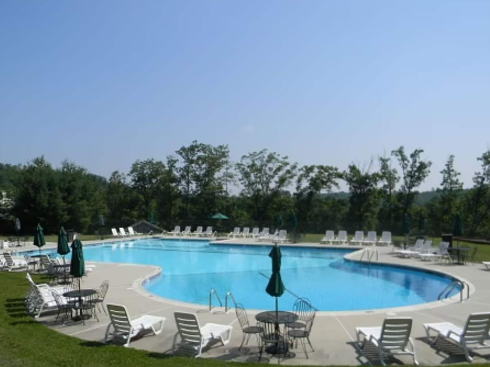 A large swimming pool surrounded by chairs and tables