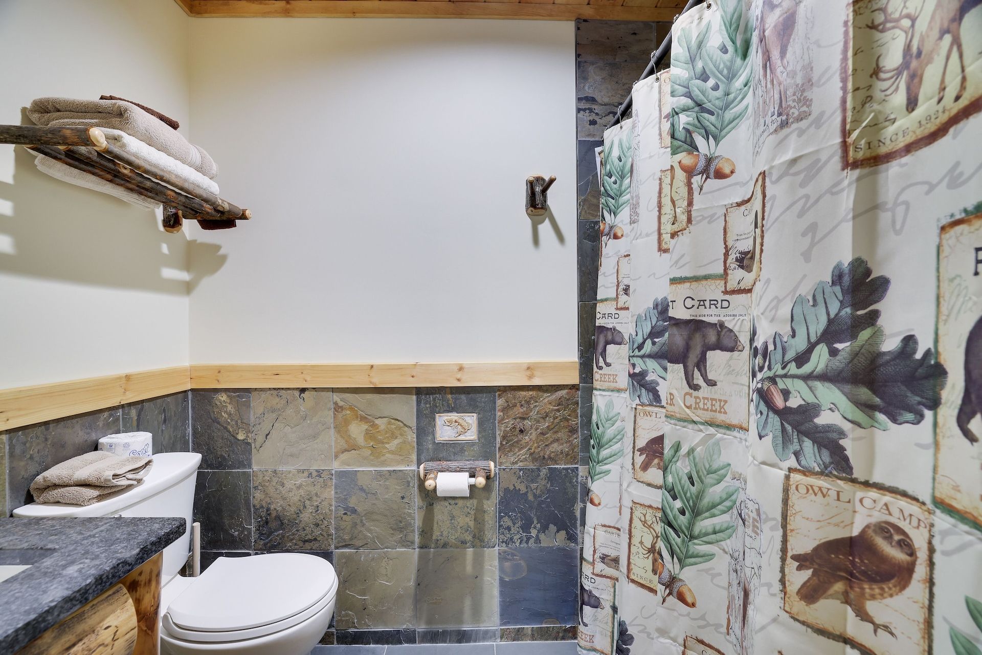 A bathroom with a toilet , sink and shower curtain.
