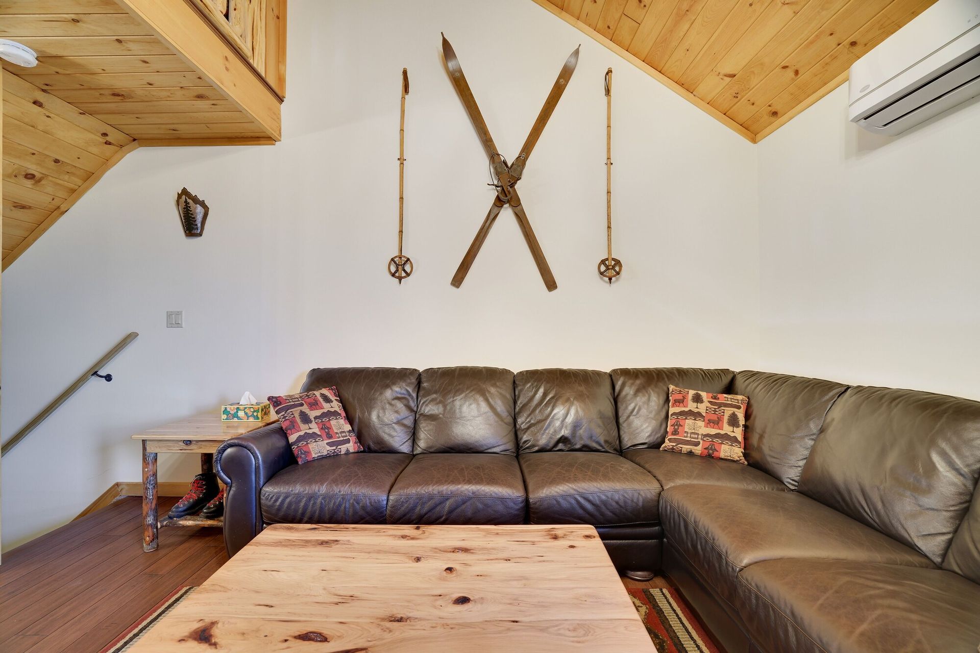 A living room with a couch and skis on the wall