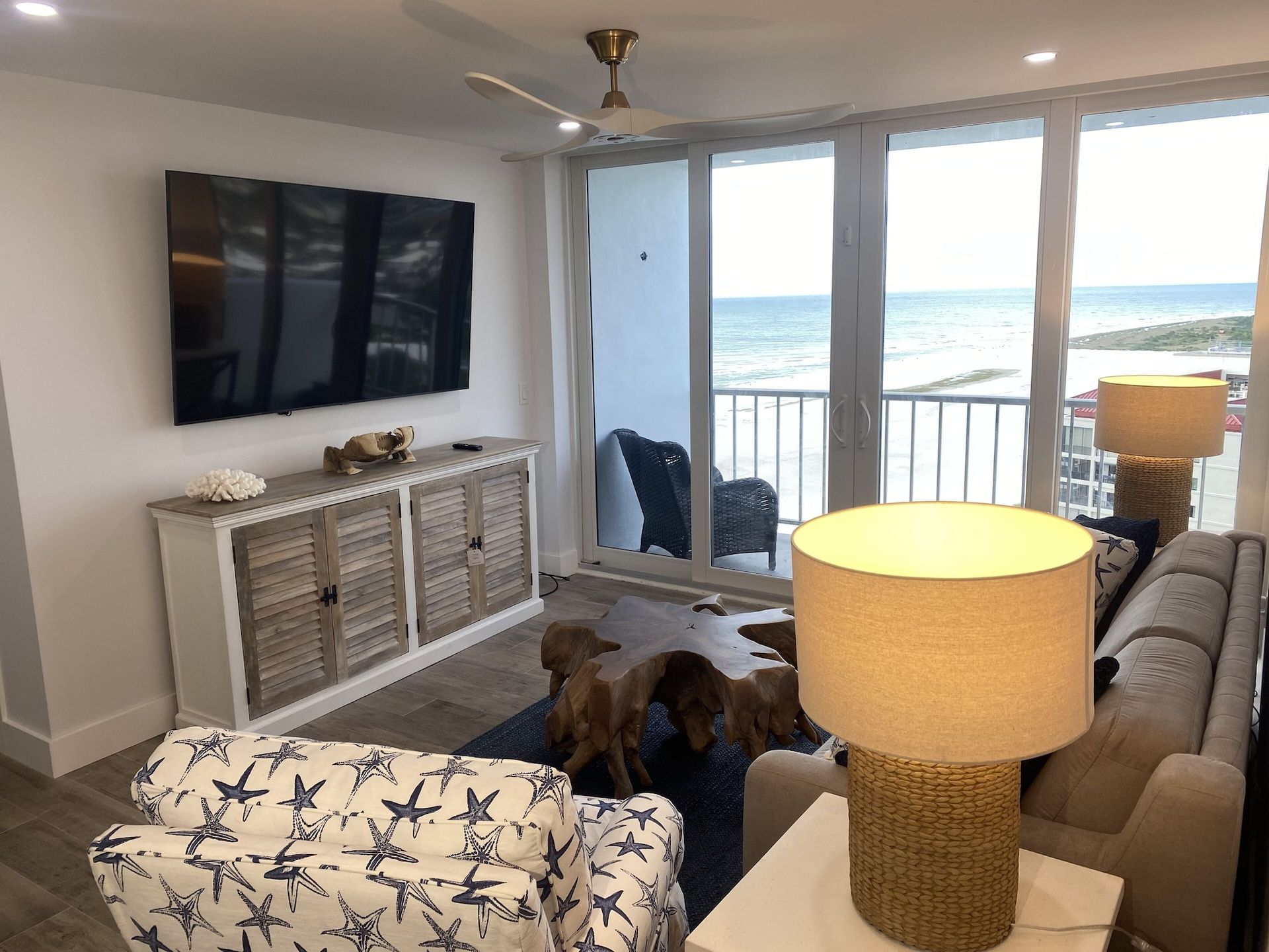 A living room with a large flat screen tv on the wall.
