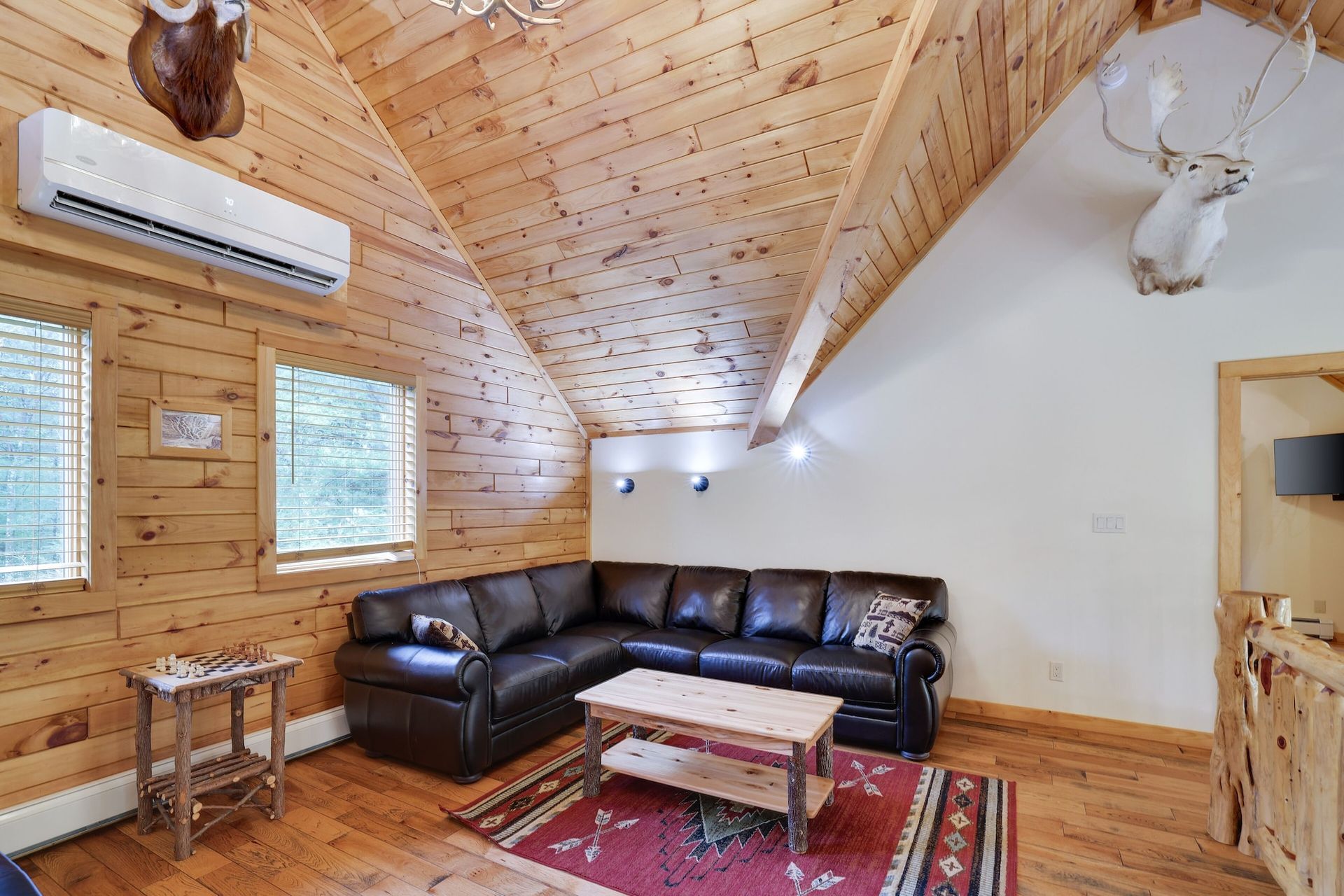 A living room in a log cabin with a couch and a coffee table.