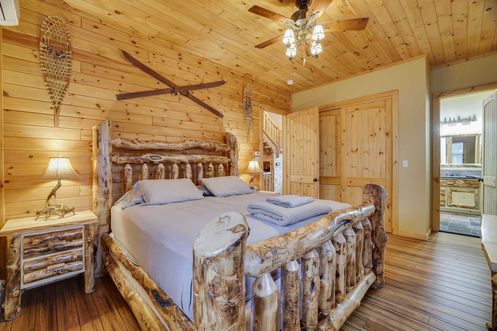 A bedroom with a wooden bed and a ceiling fan.