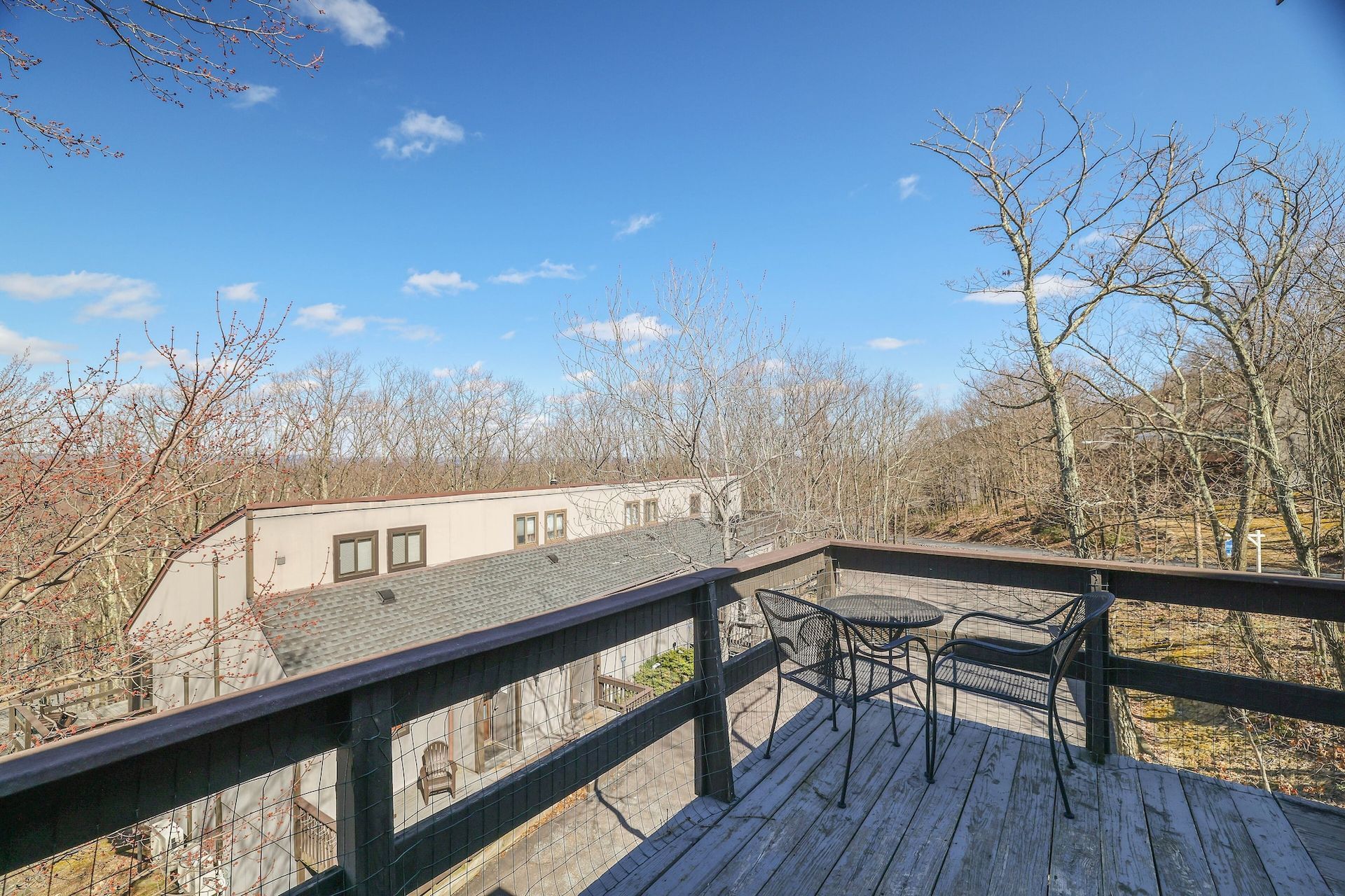 There is a deck with a table and chairs on it.