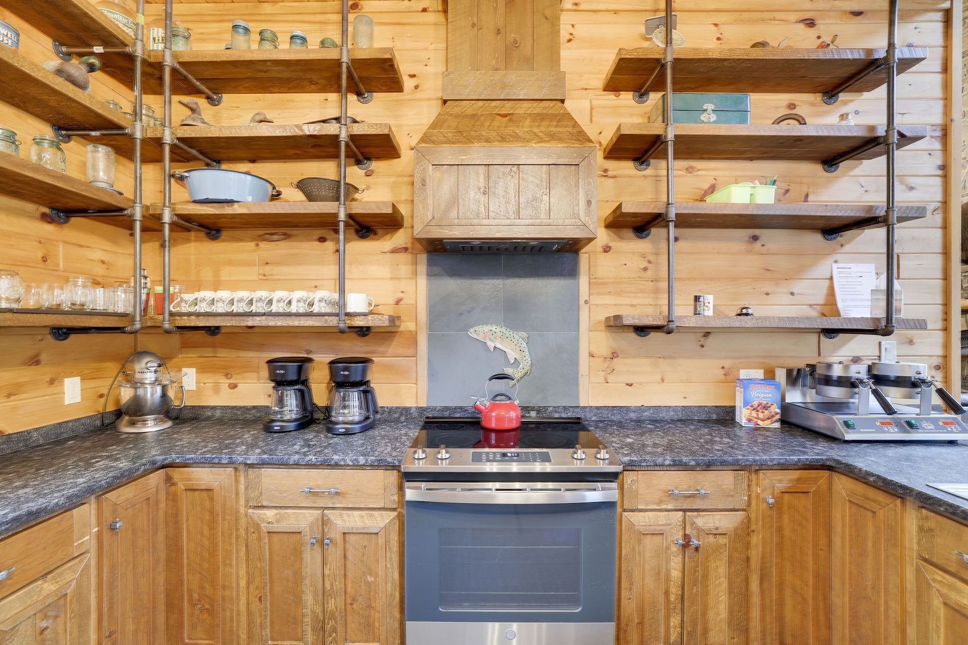 A kitchen in a log cabin with stainless steel appliances and wooden cabinets.