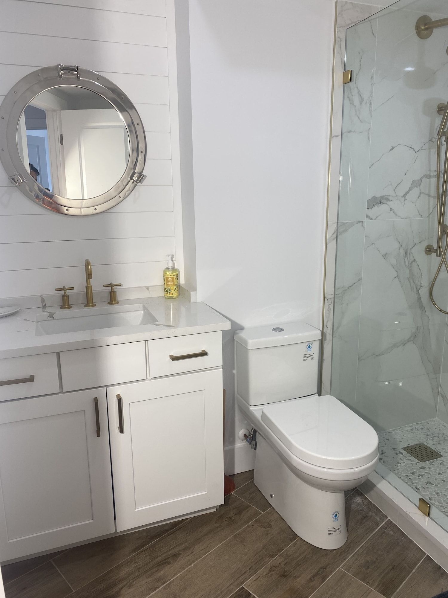 A bathroom with a toilet , sink and shower.