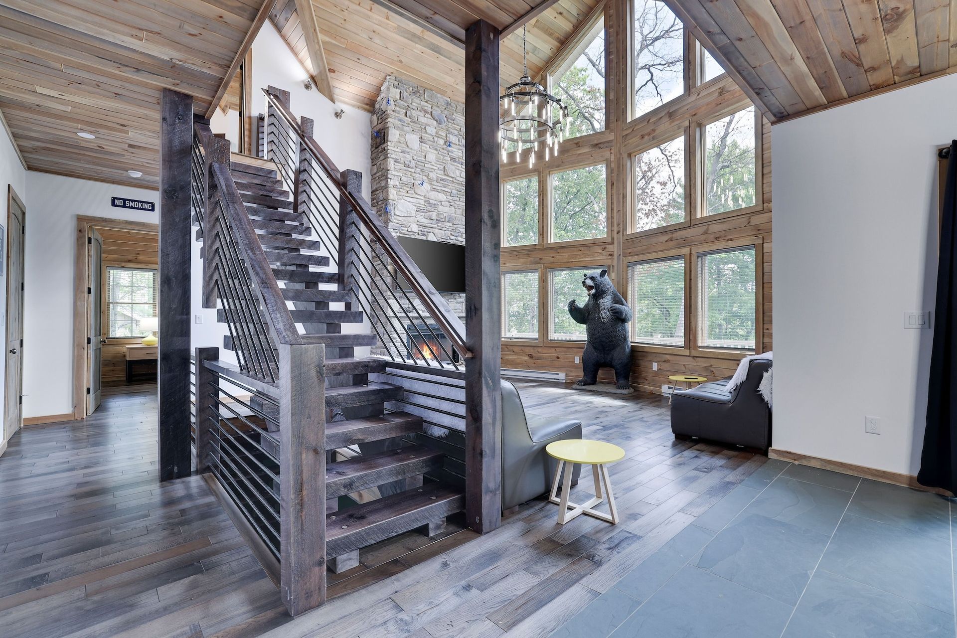 A living room with a staircase and a statue of a bear