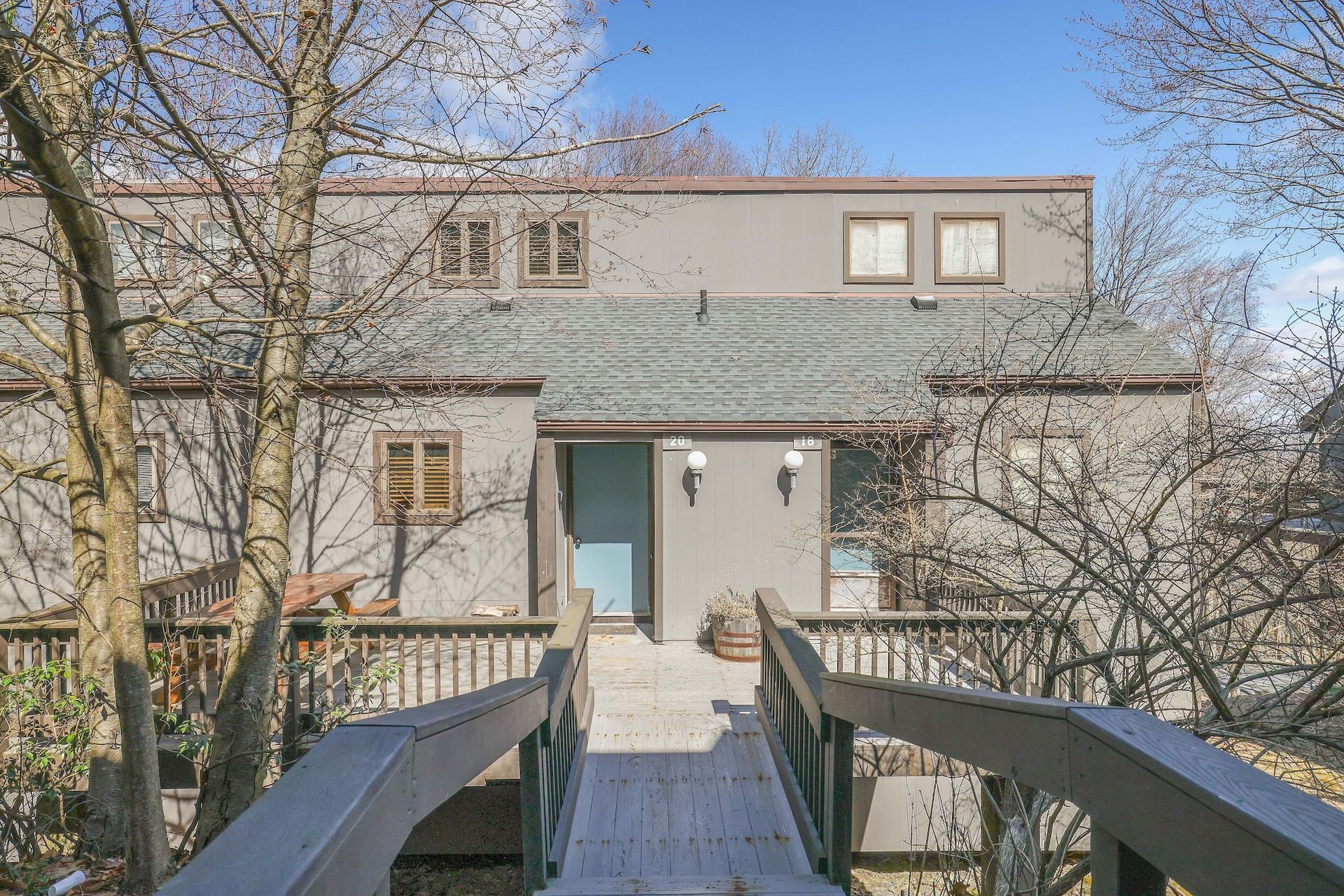 There is a bridge leading to the front of the house.