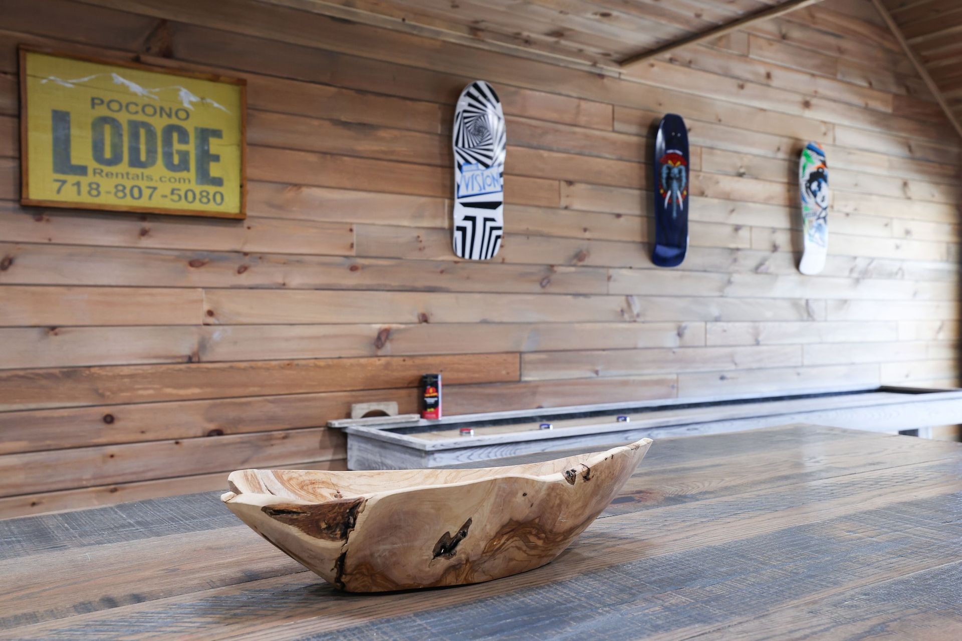 A bowling alley with skateboards hanging on the wall and a sign that says lodge.