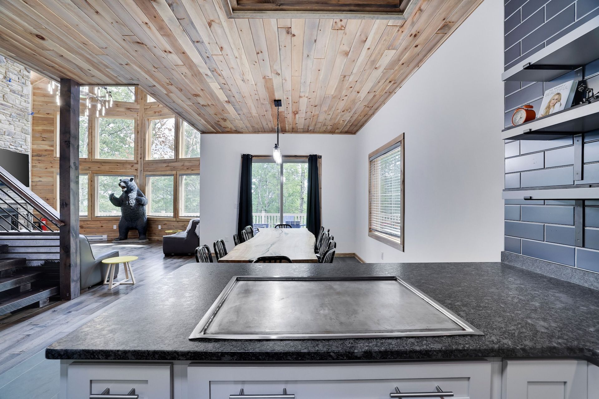 A kitchen with a stove top oven and a table in the background.