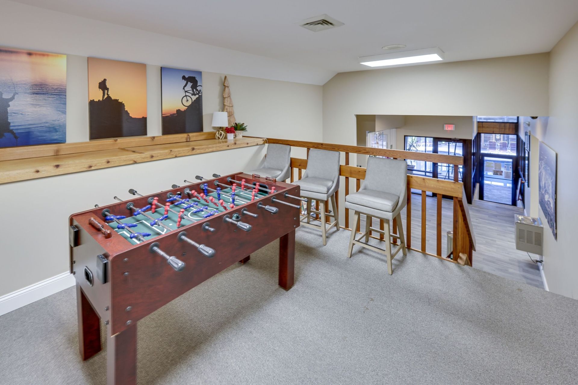A game room with a foosball table and chairs