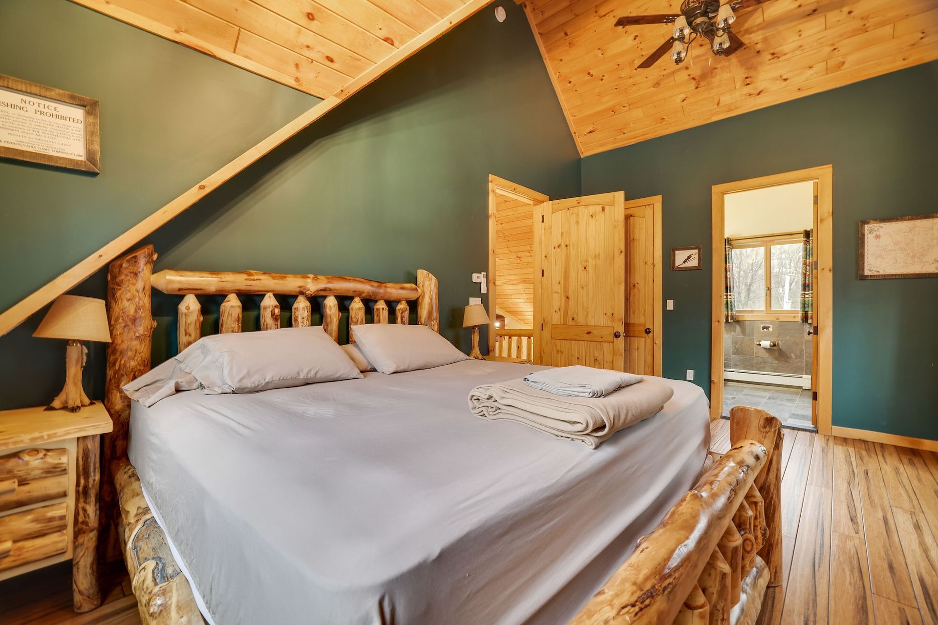 A bedroom with a king size bed and a ceiling fan.