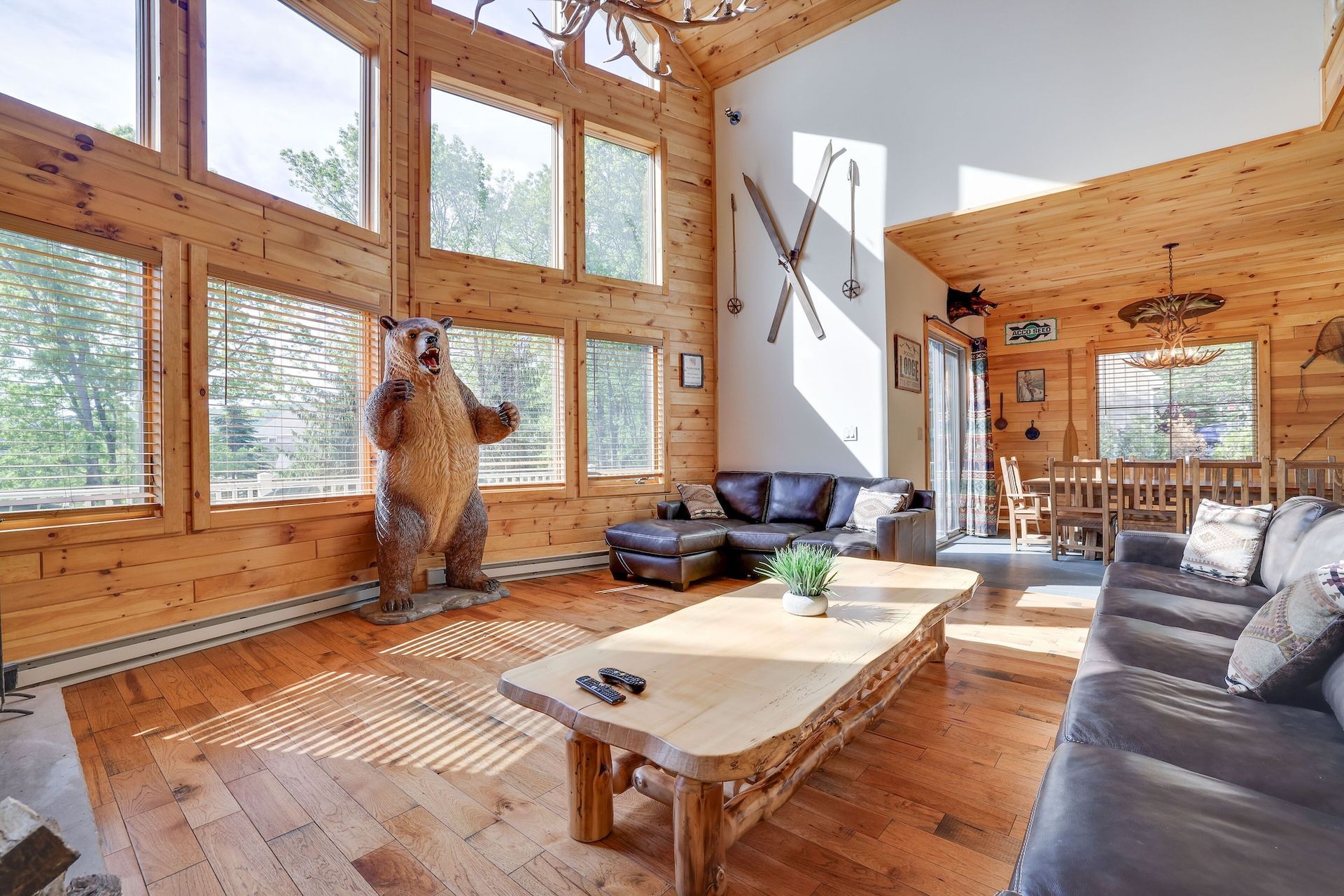 A large house with a large deck is sitting on top of a hill surrounded by trees.