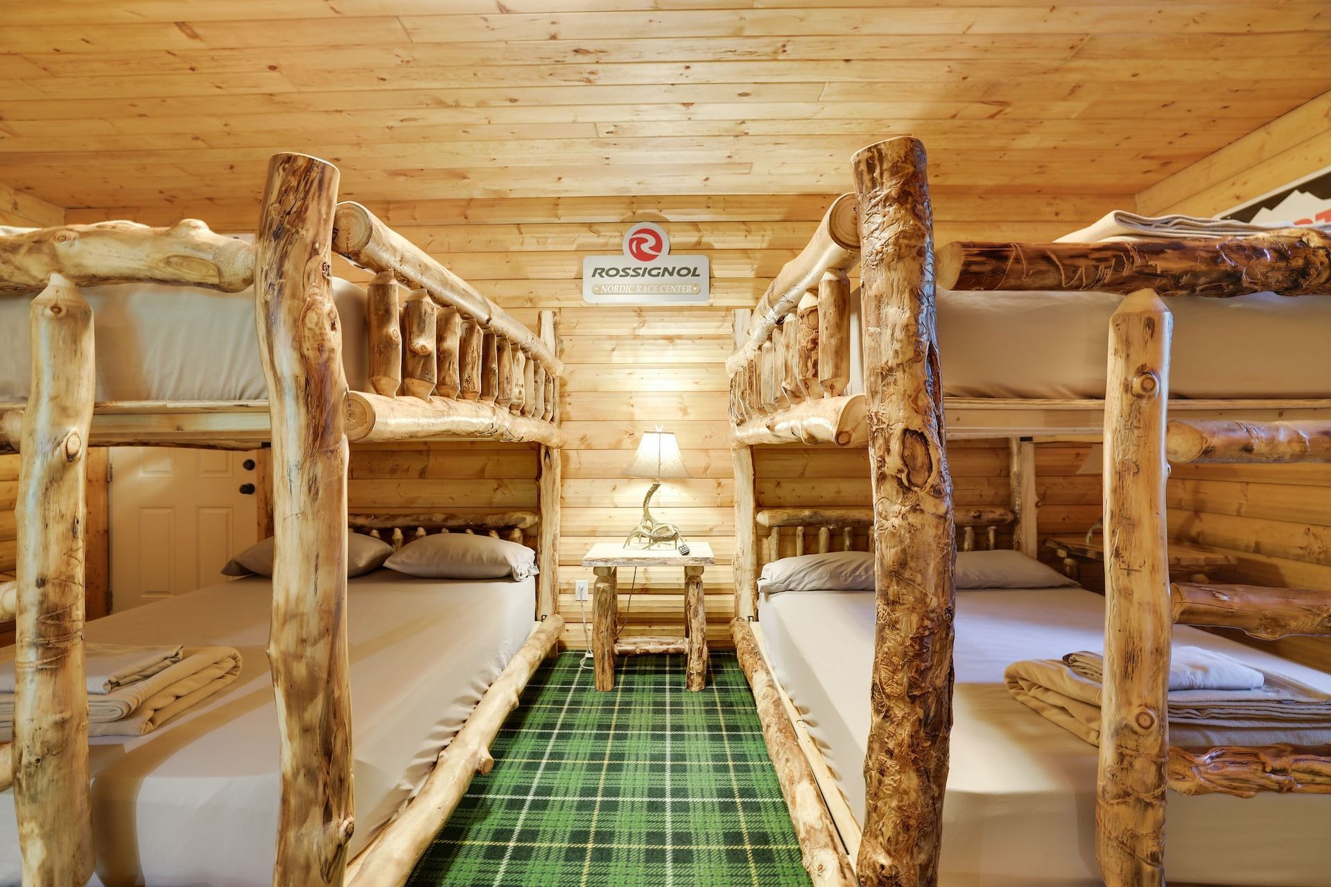 A room with bunk beds made of logs in a log cabin.