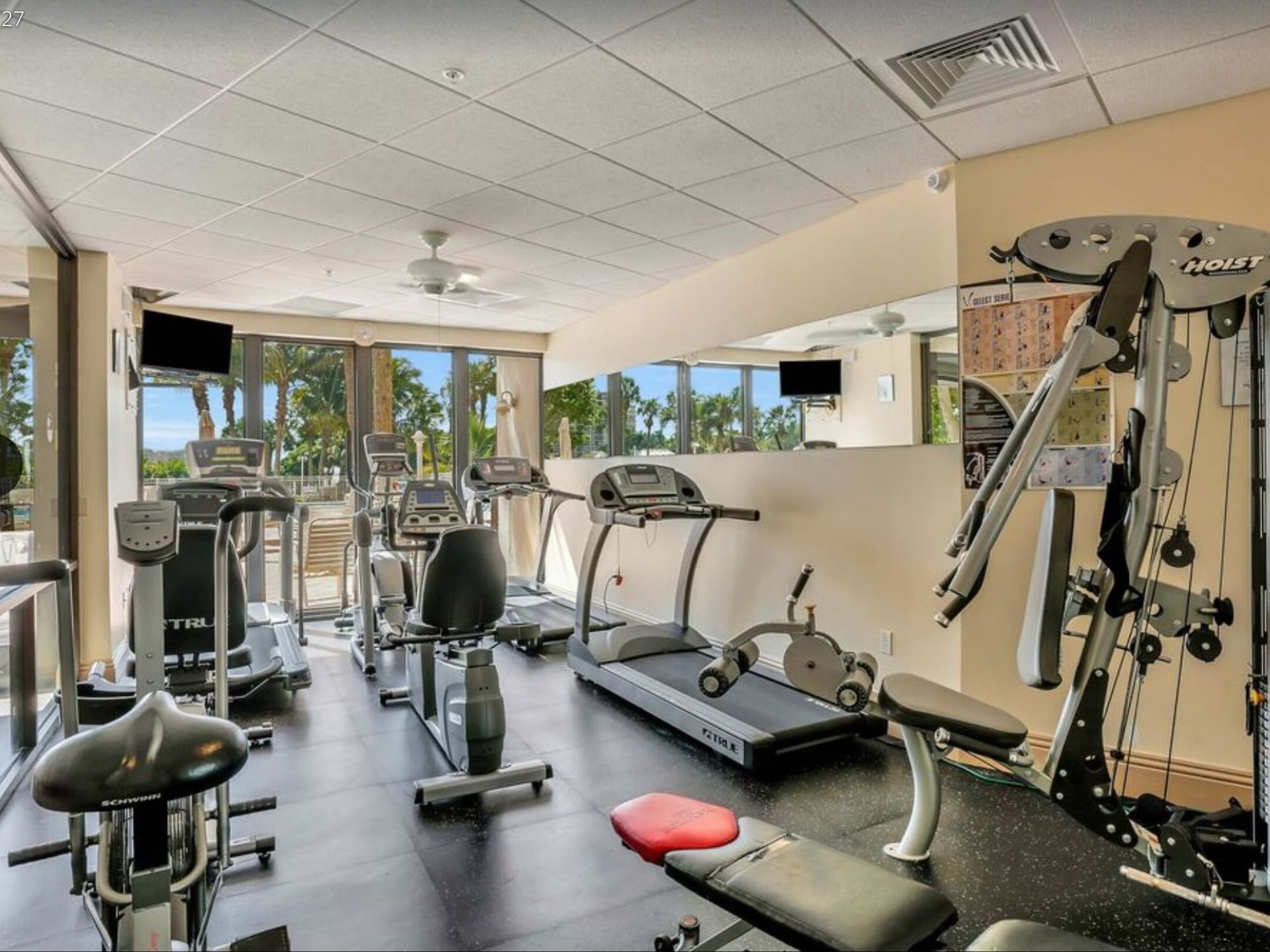 A gym with a lot of equipment including treadmills and bikes