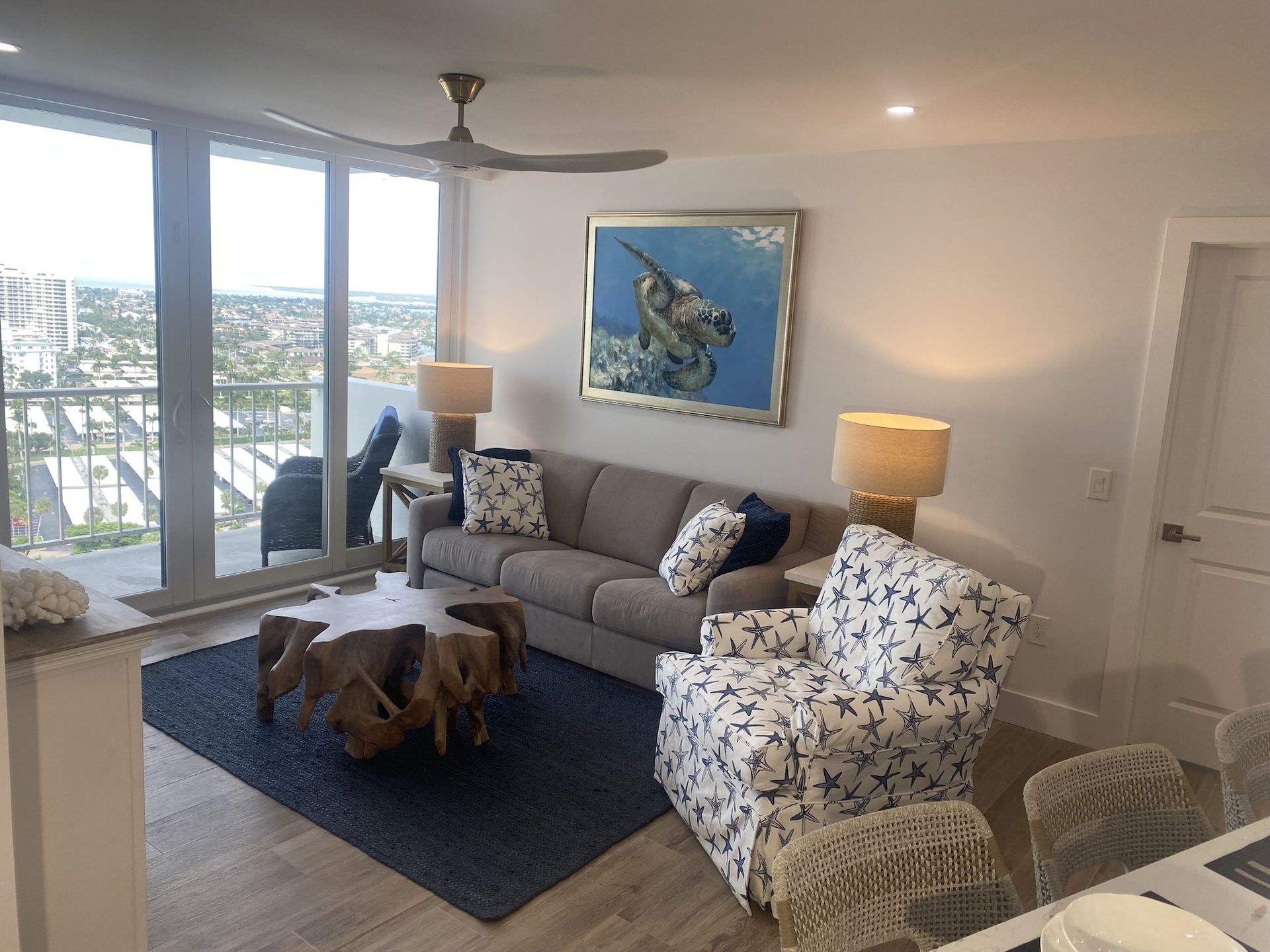 A living room with a couch , chair , table and a ceiling fan.
