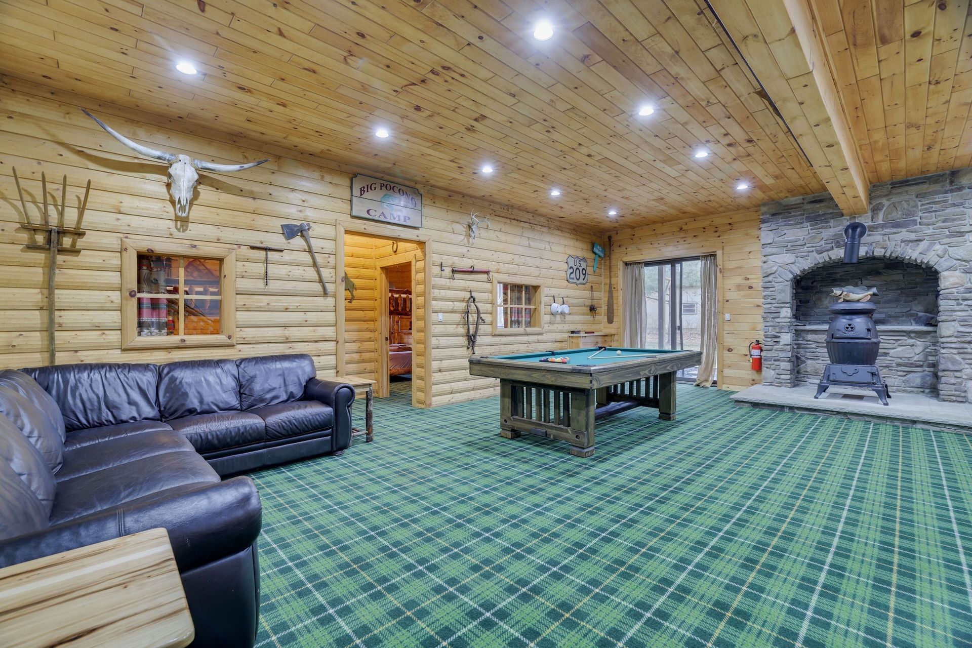 A living room with a pool table and a couch.