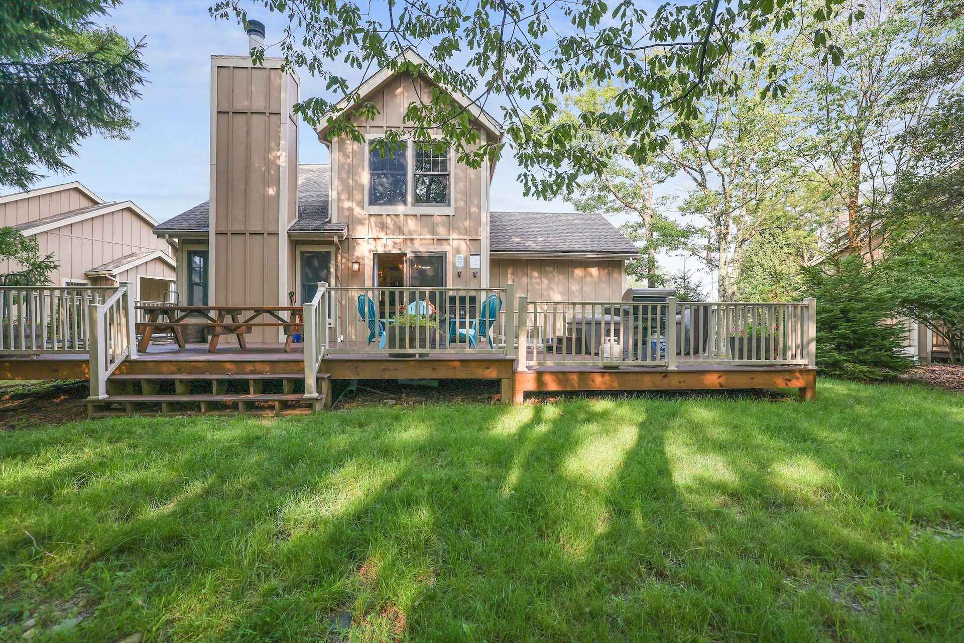 A large house with a large deck in the backyard.
