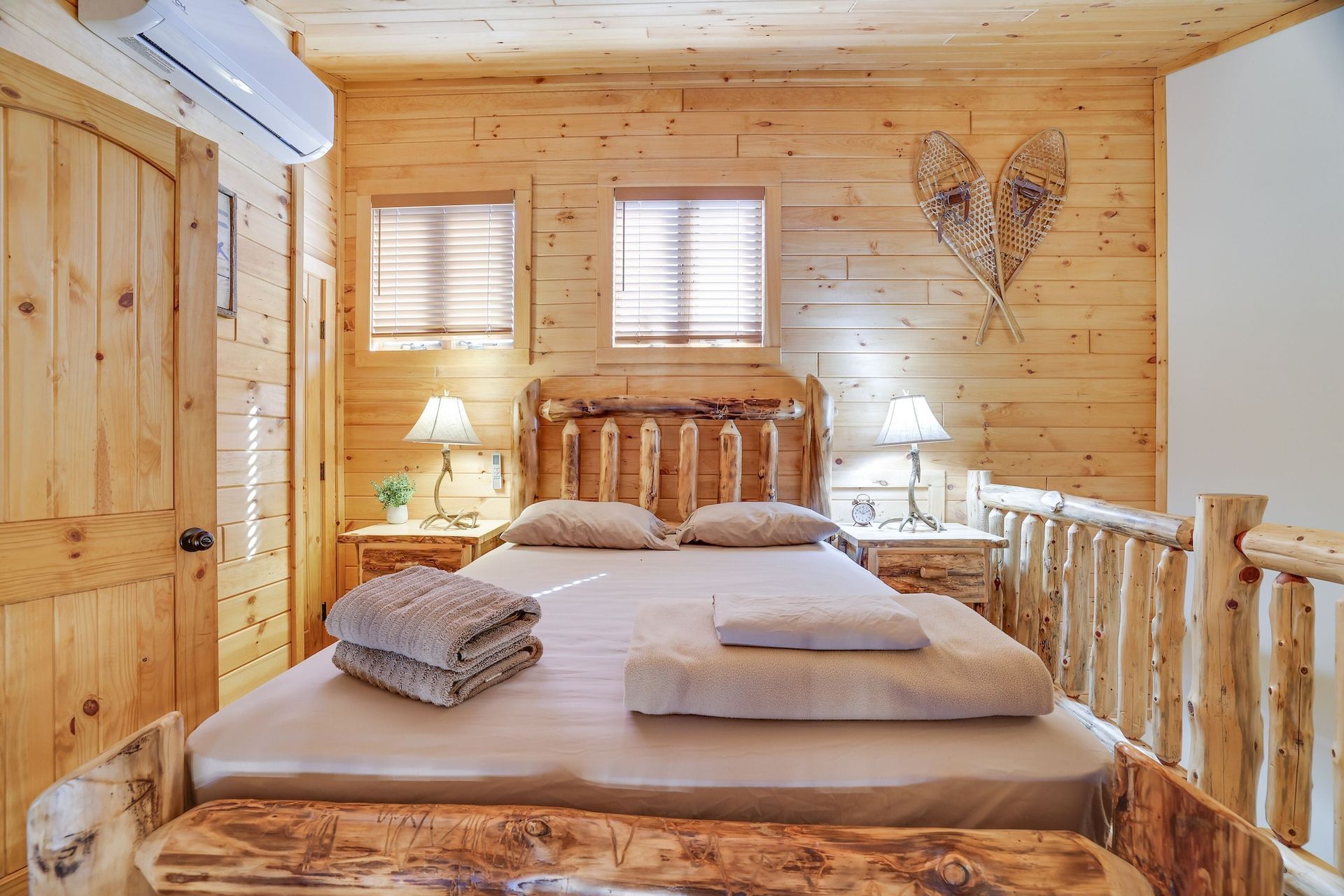 A bedroom in a log cabin with a king size bed and two nightstands.