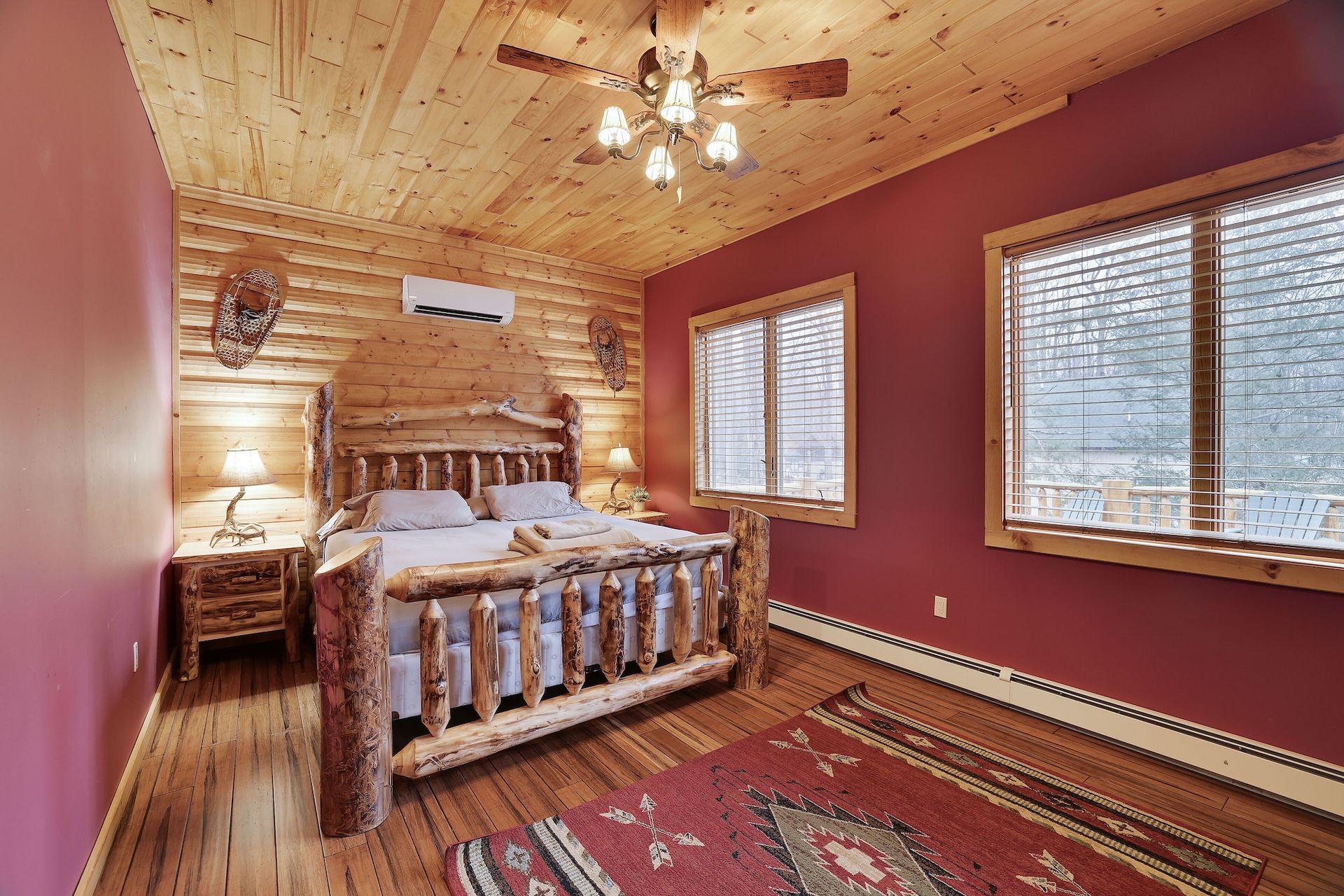 A bedroom in a log cabin with a king size bed and a ceiling fan.