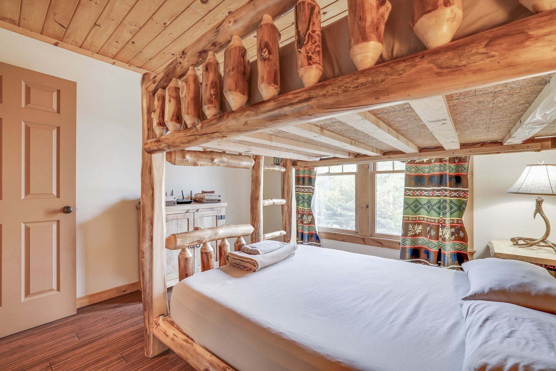 A bedroom with a bunk bed made of logs.