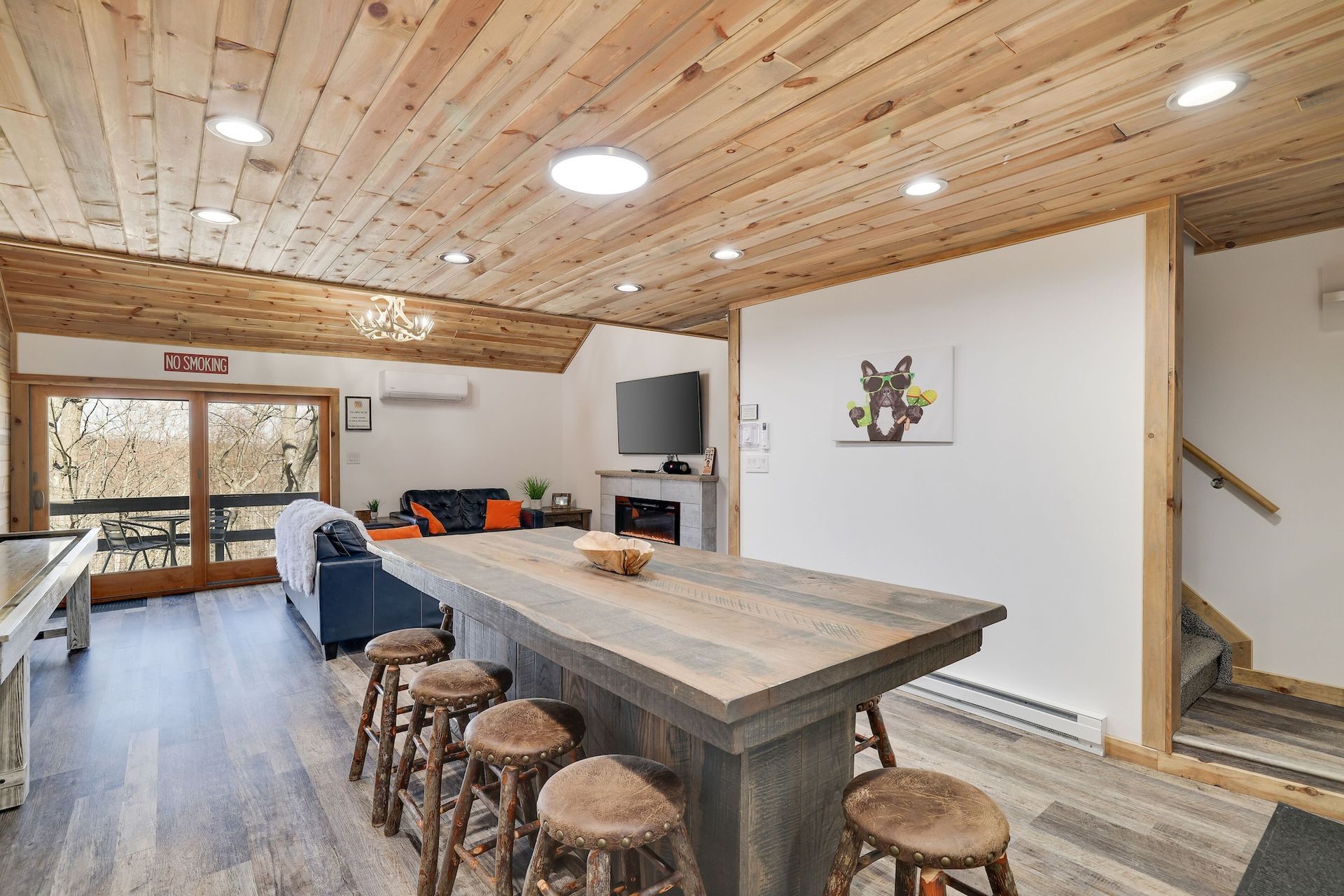 A living room with a long wooden table and stools