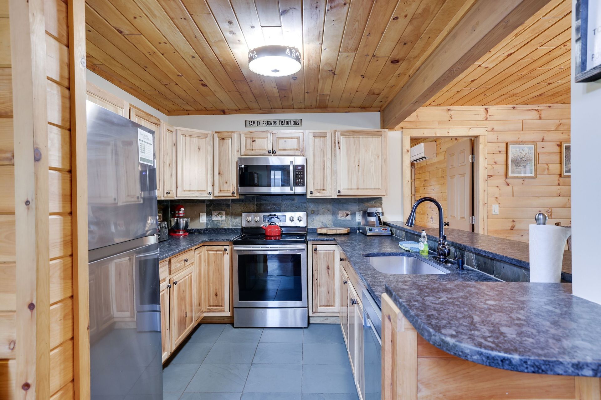A kitchen in a log cabin with stainless steel appliances and granite counter tops