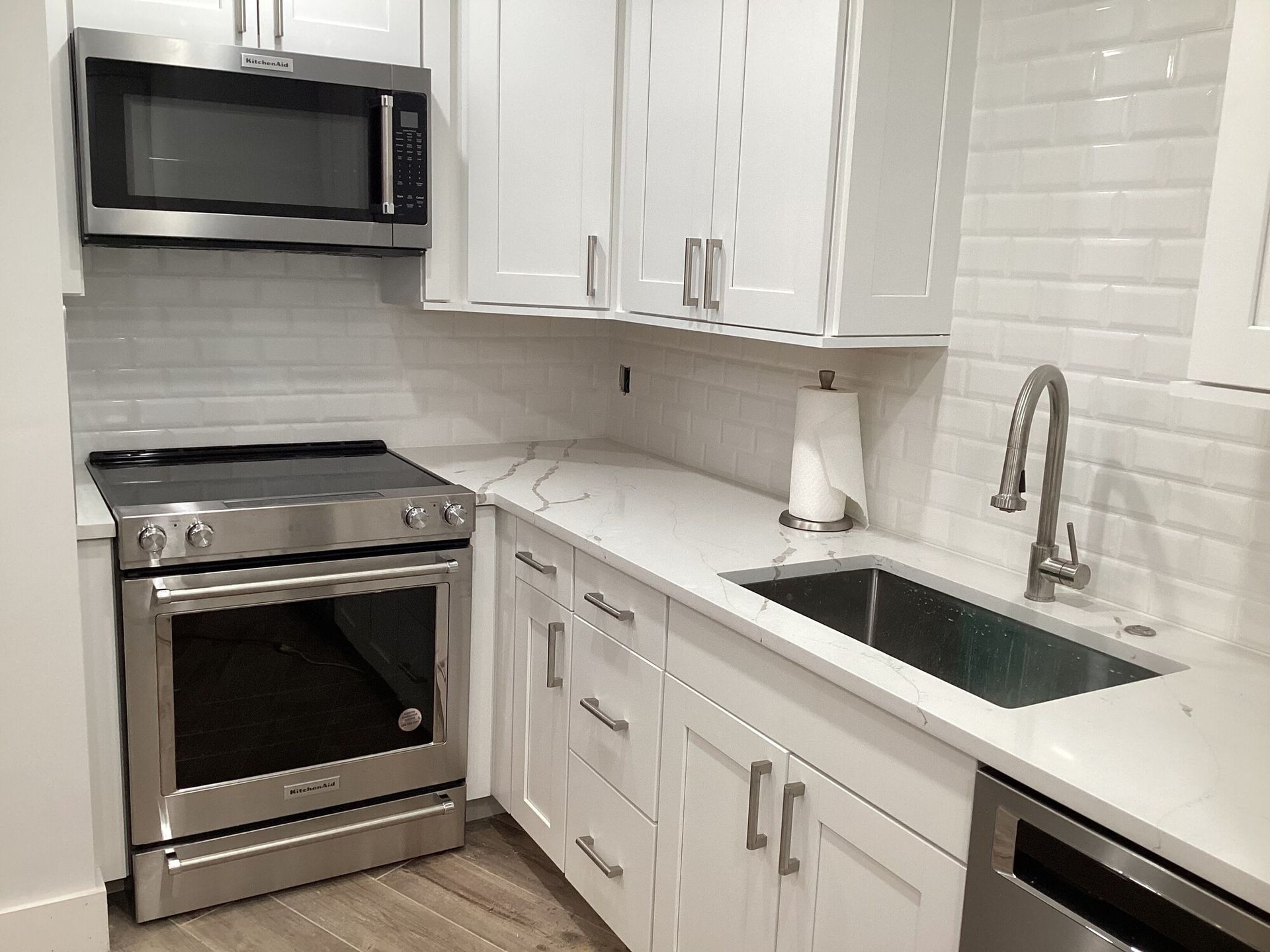 A kitchen with stainless steel appliances and white cabinets