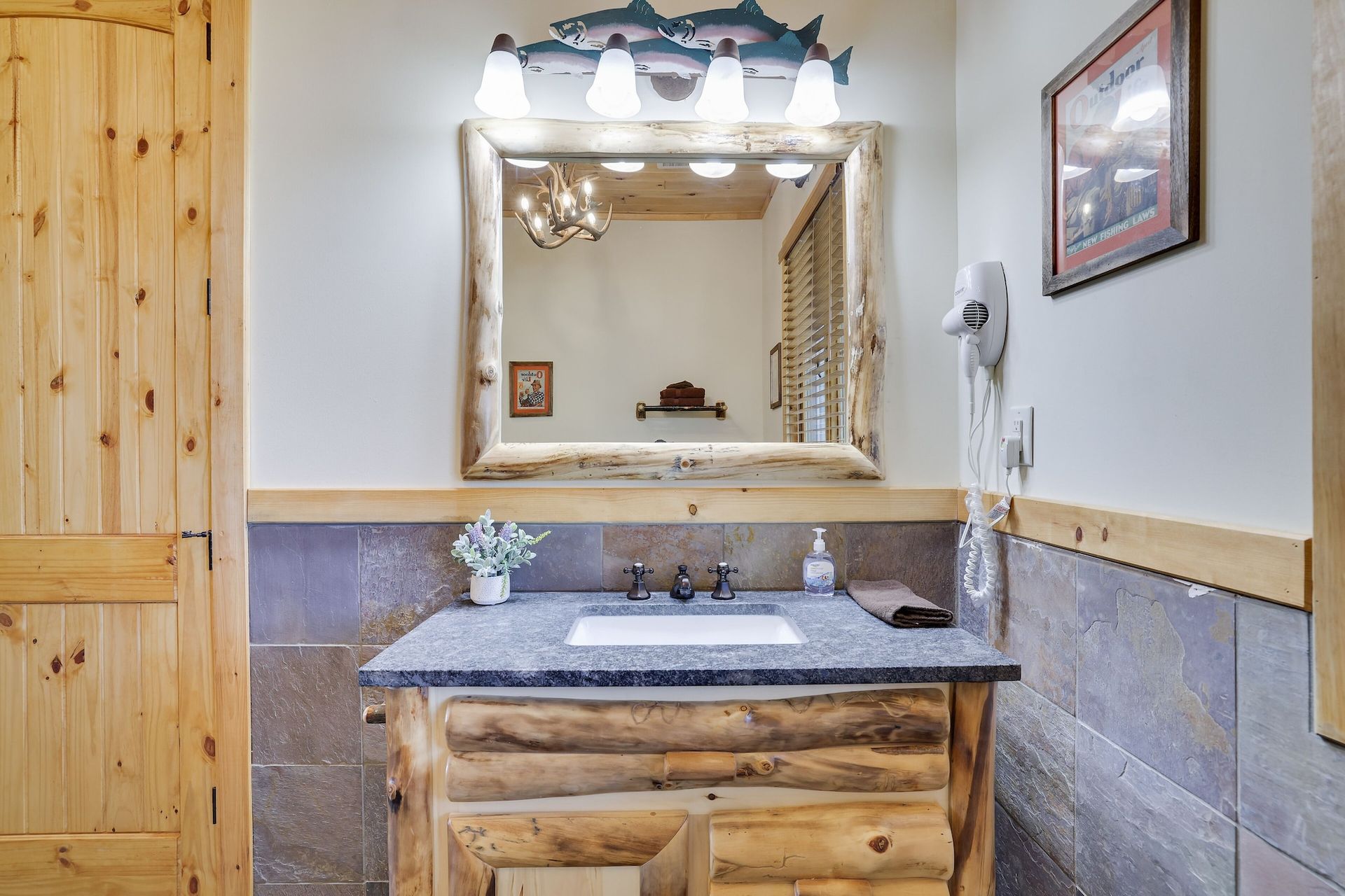A bathroom with a sink , mirror and wooden cabinets.