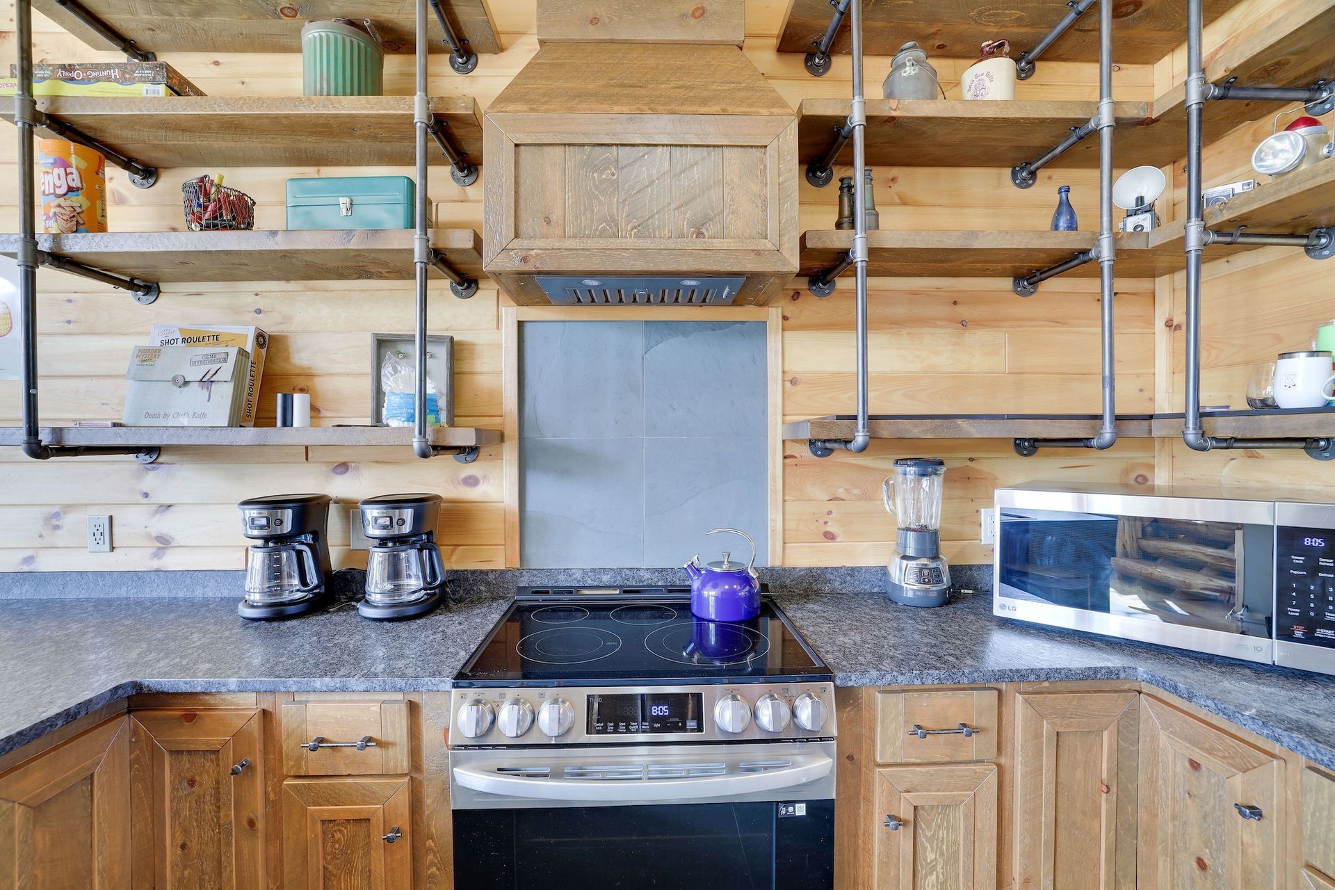 A kitchen with a stove , microwave , and coffee maker.