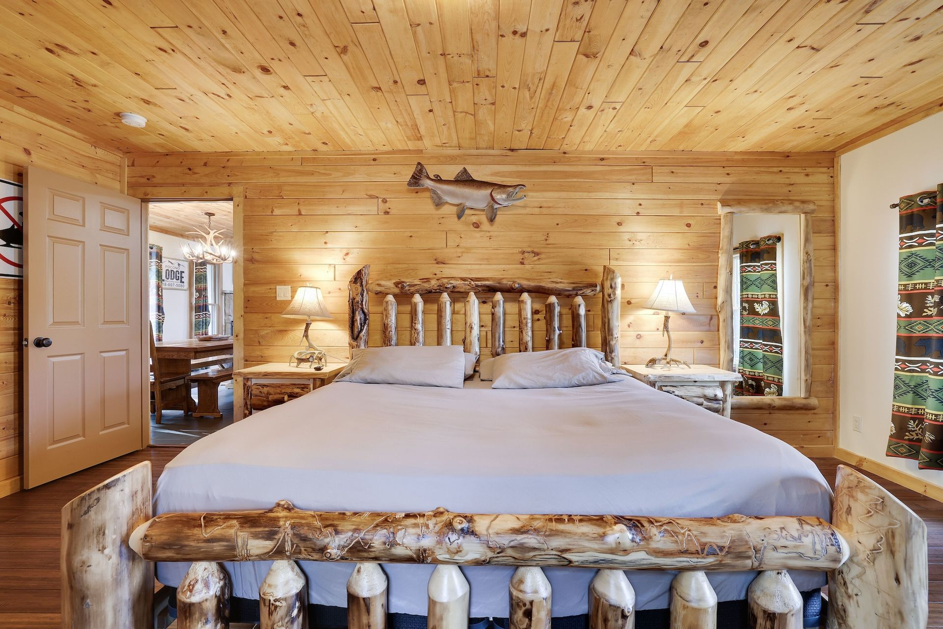 A bedroom in a log cabin with a king size bed.