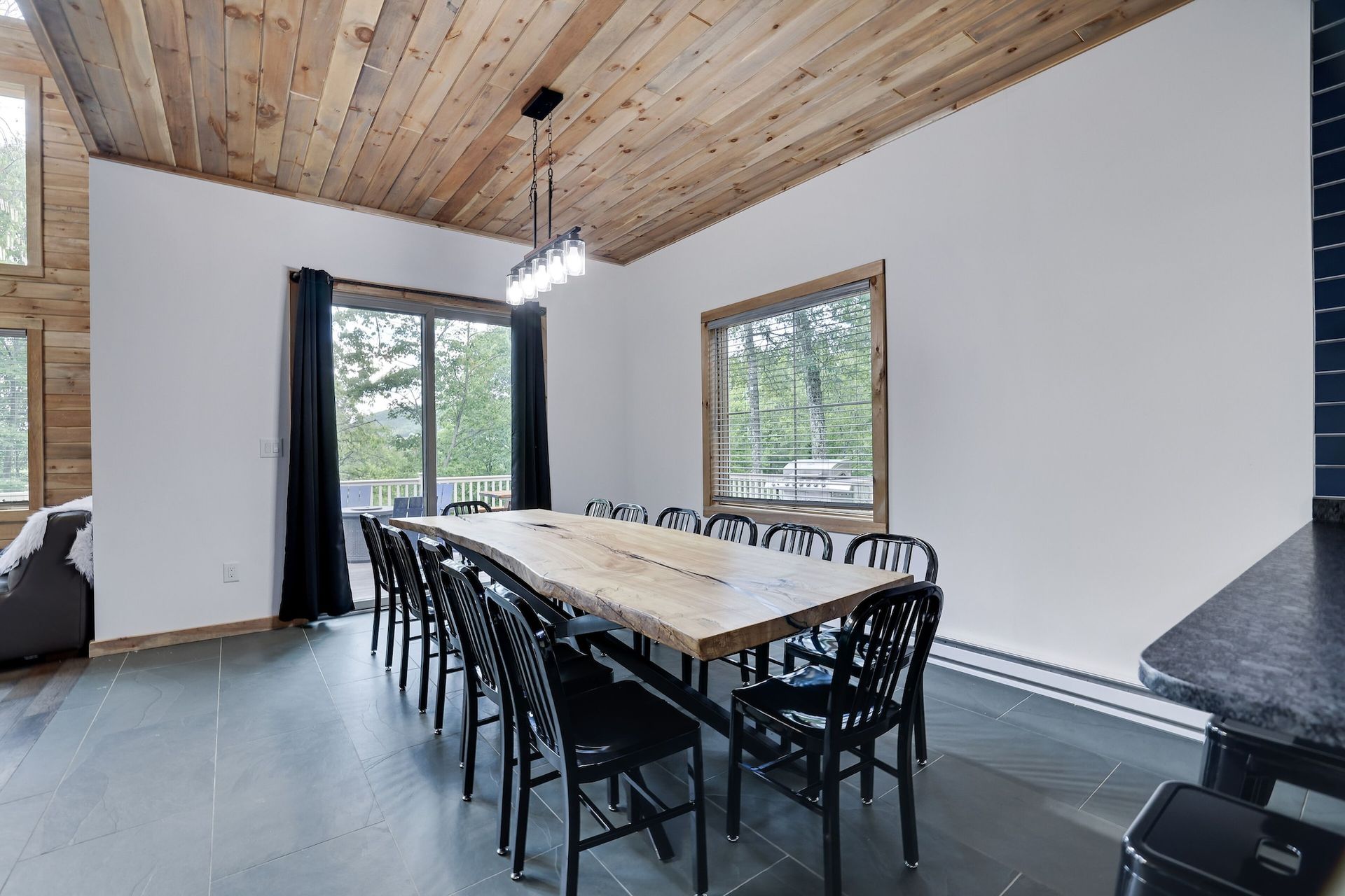 A dining room with a long wooden table and chairs.