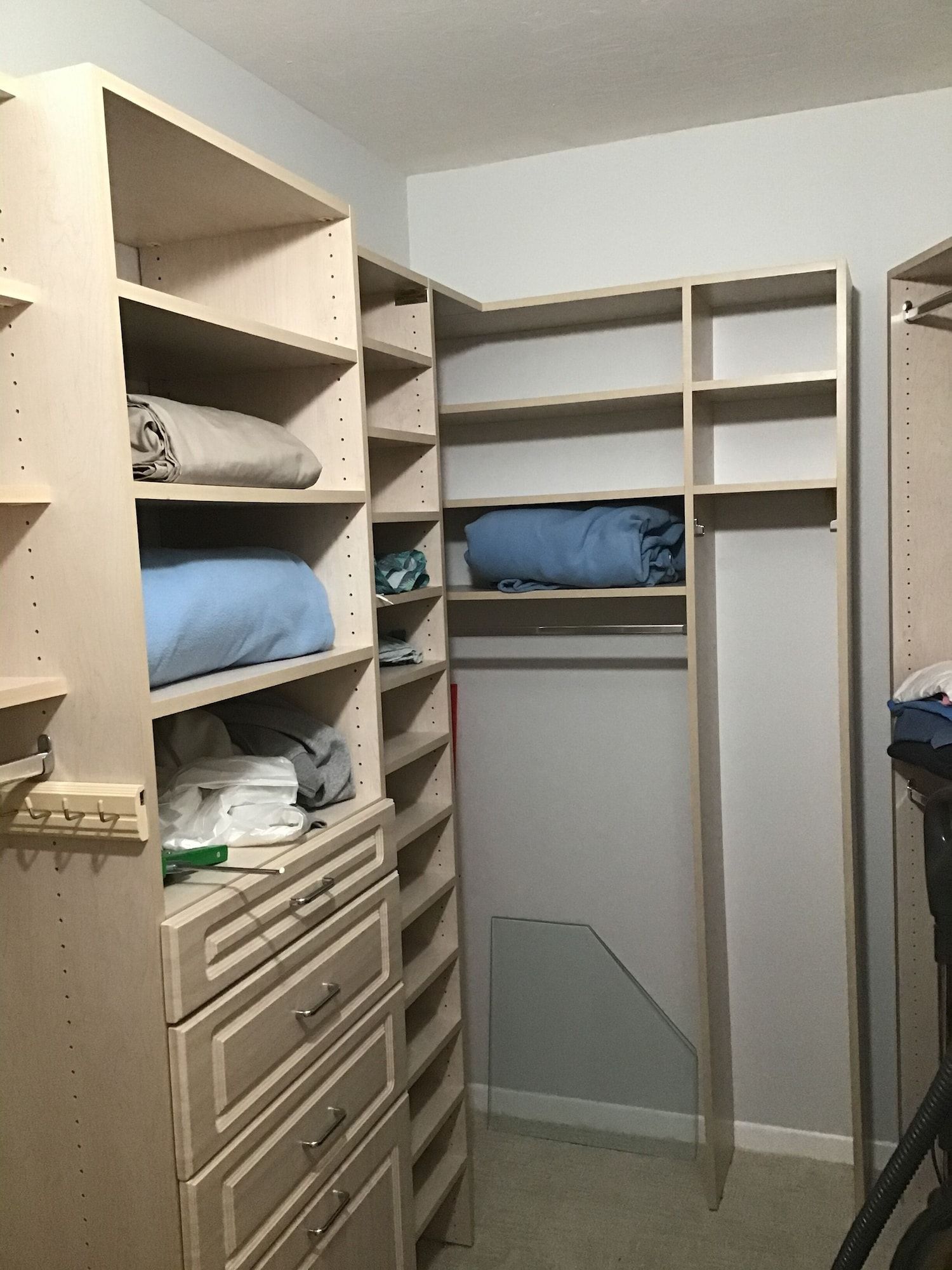A walk in closet with lots of shelves and drawers