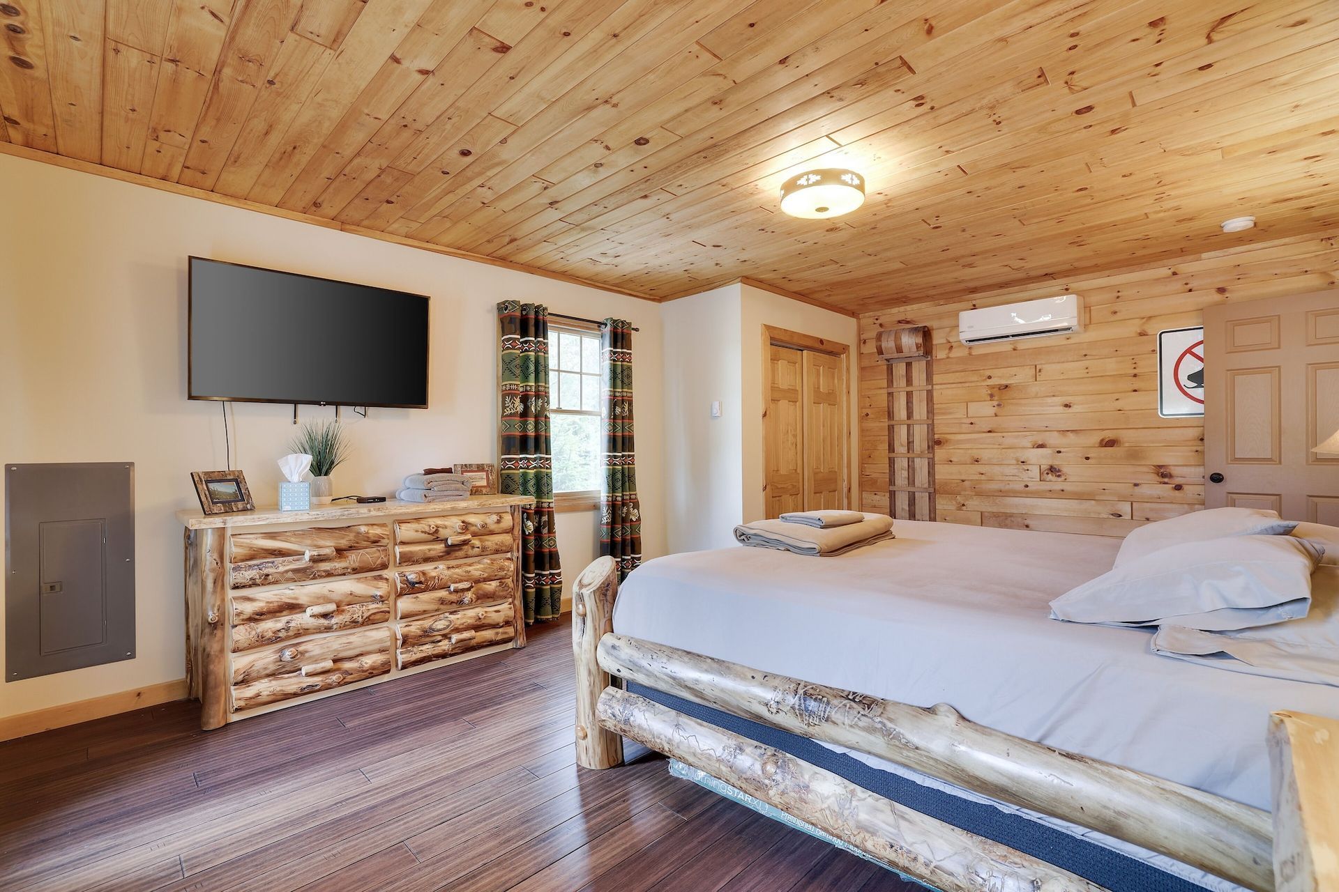 A bedroom with a bed , dresser , and television.