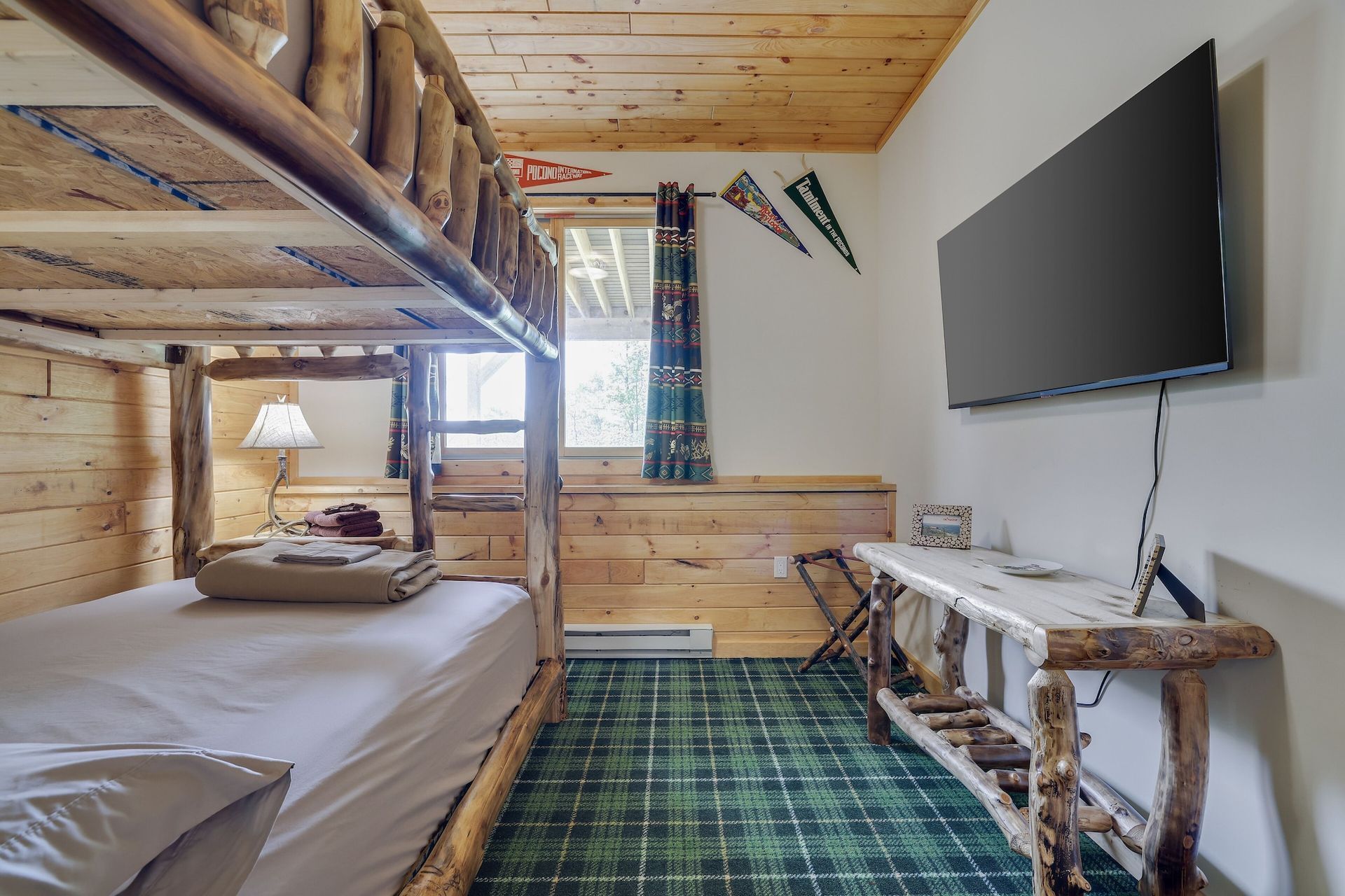 A bedroom with bunk beds and a flat screen tv.