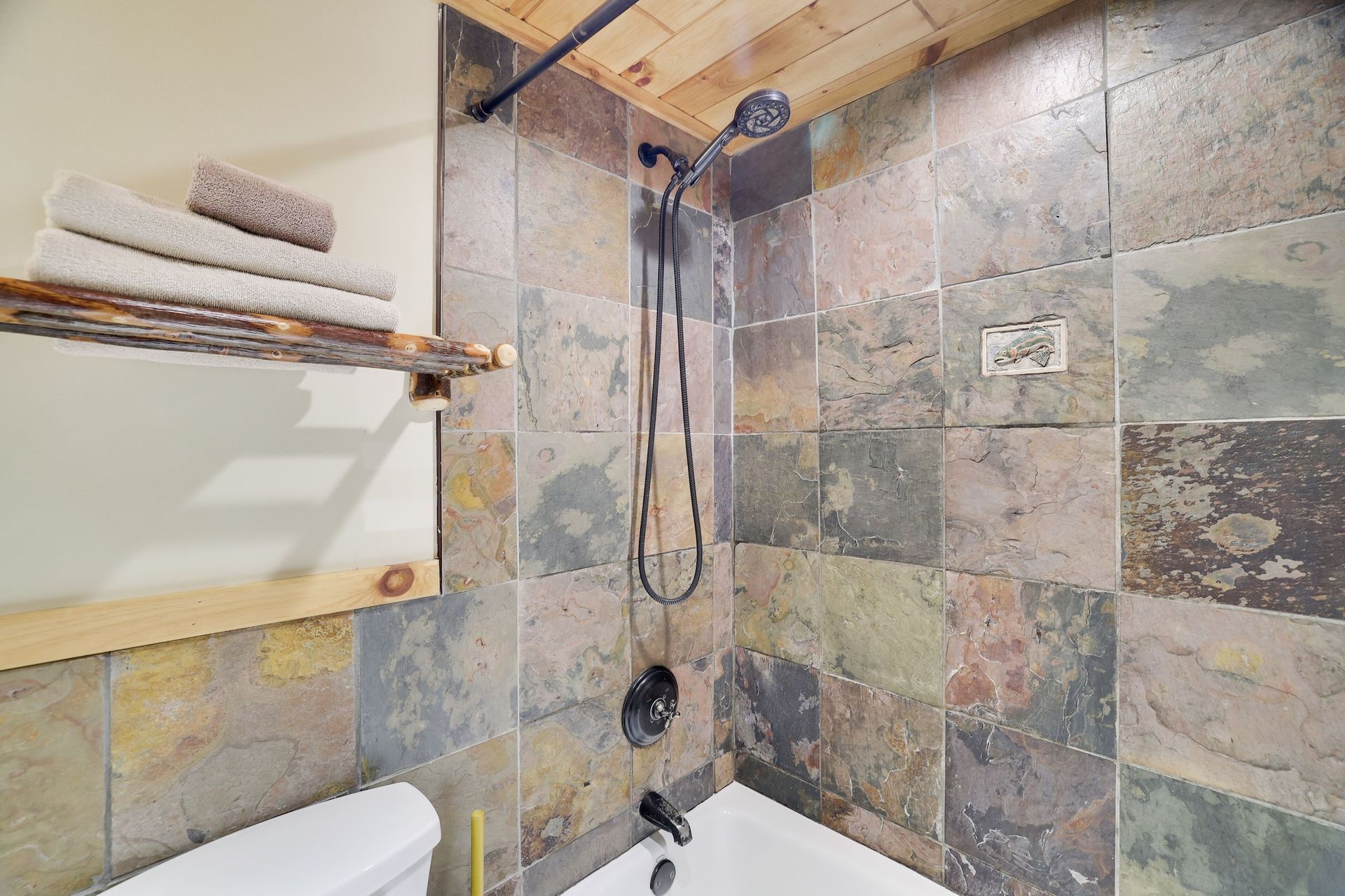 A bathroom with a bathtub , toilet and shower.