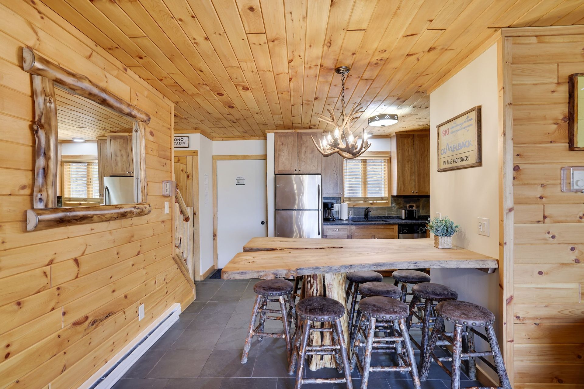 A kitchen in a log cabin with a table and stools